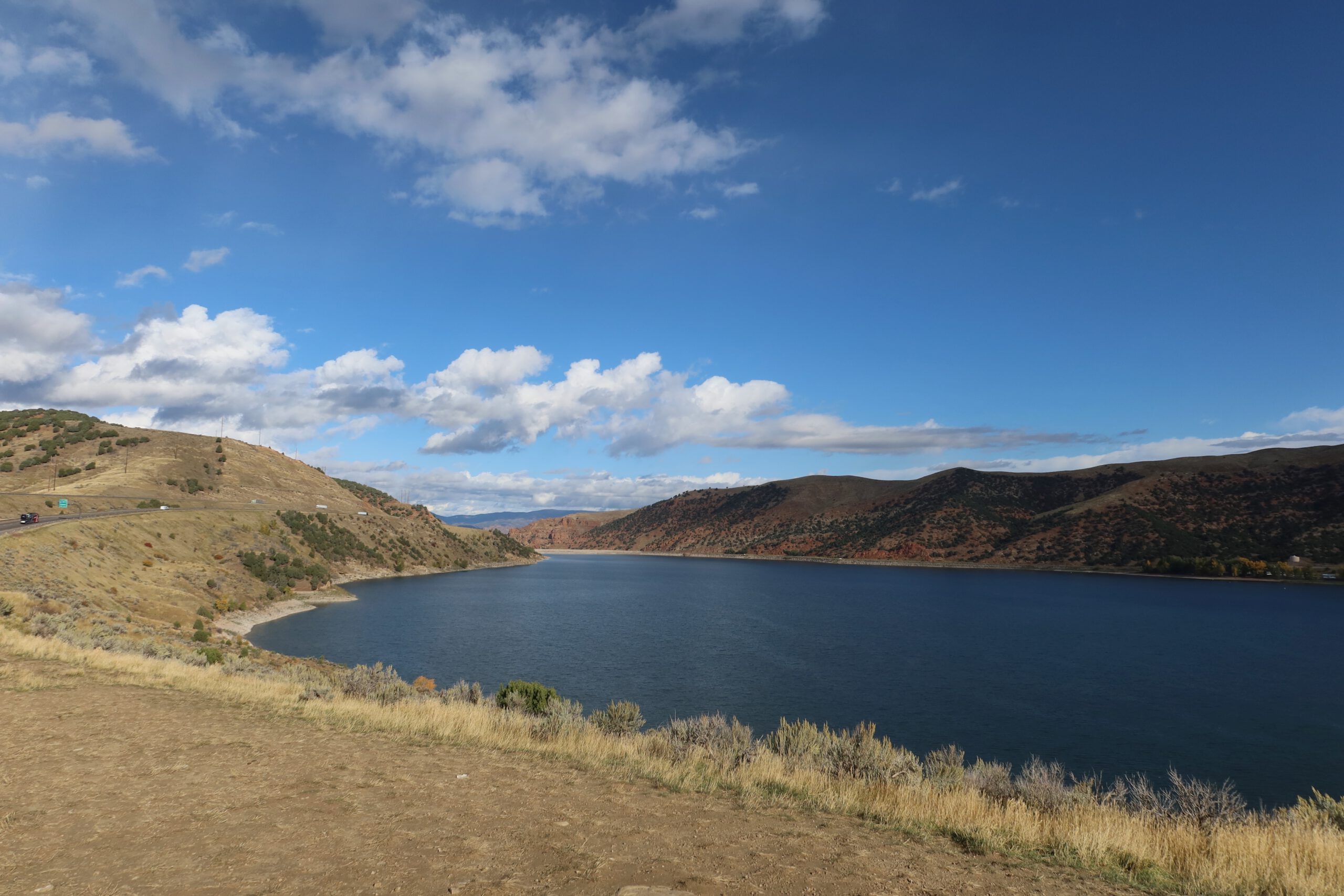 Scenic overlook of Echo Reservoir Utah near Coalville Utah, with deep blue water framed by dry hills and soft clouds, photographed from a quiet roadside viewpoint along Interstate 80.