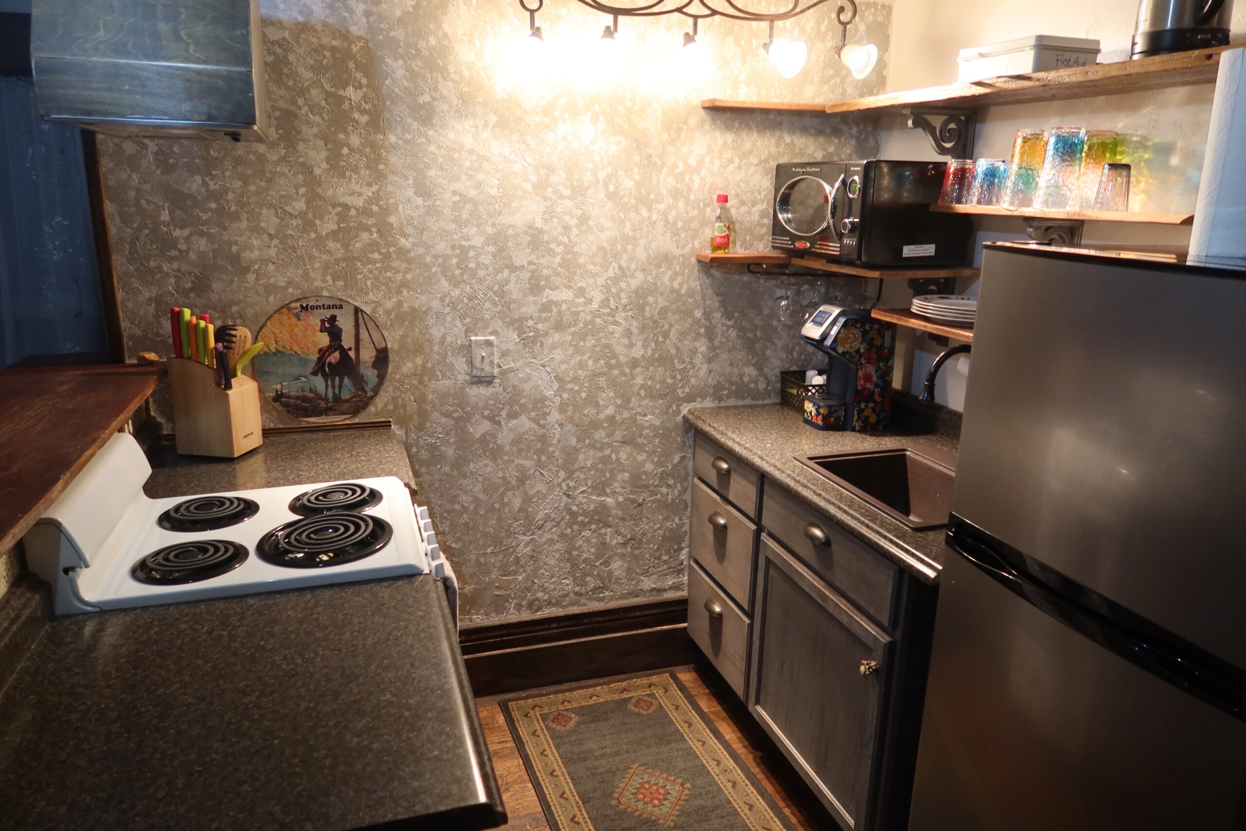 Kitchenette in room 201 at Park Hotel Yellowstone in Gardiner Montana, compact western style hotel kitchen with stove fridge microwave and sink