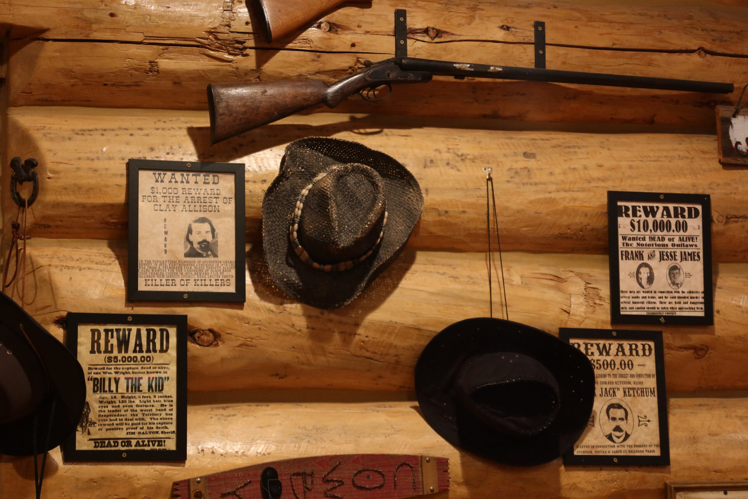 Classic Wild West wall decor with wanted posters, cowboy hats and vintage rifle inside Cowboy’s Lodge and Grille Gardiner