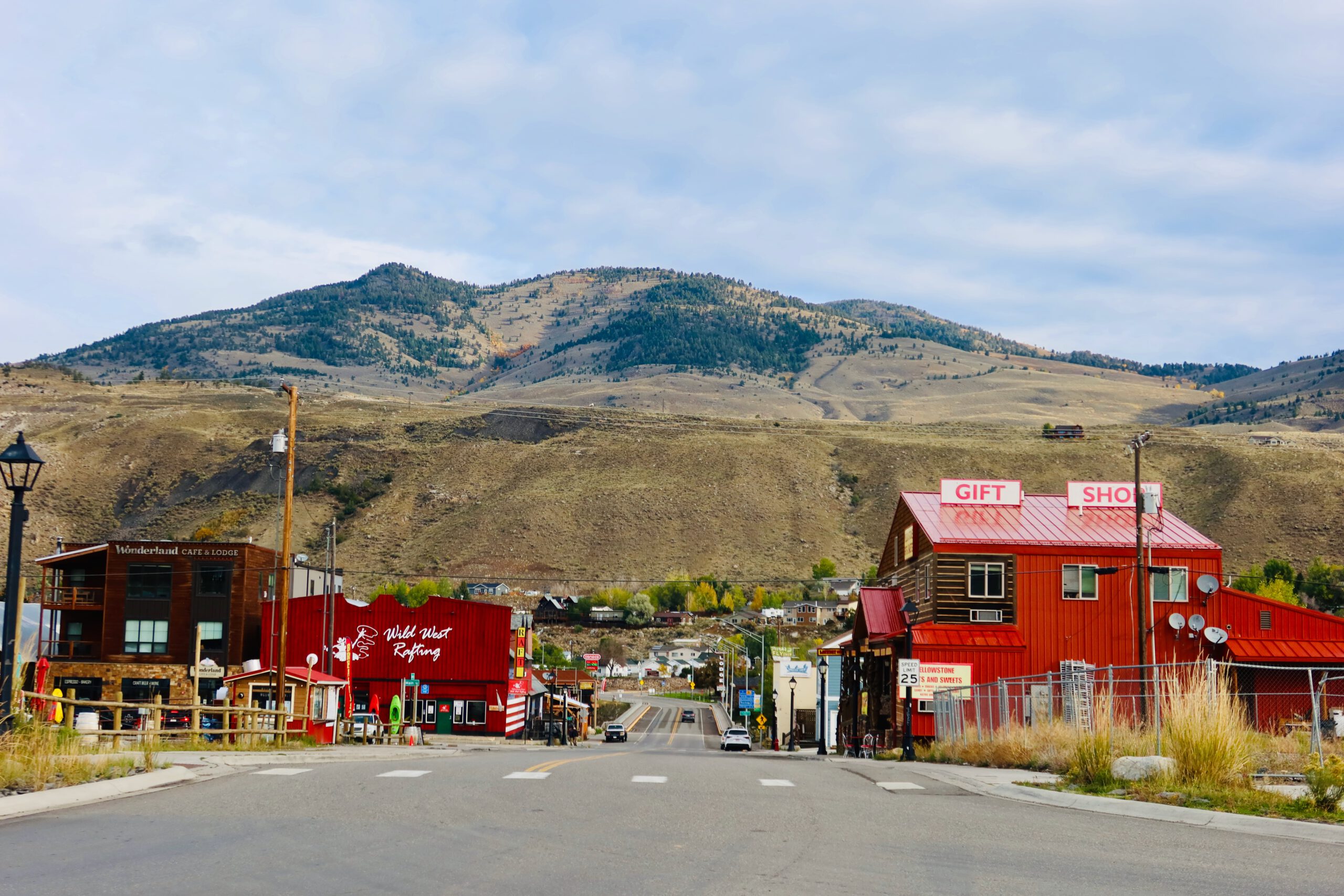 Main street of Gardiner Montana with colorful Western buildings, gift shops and lodges, surrounded by rolling hills near the North Entrance of Yellowstone National Park