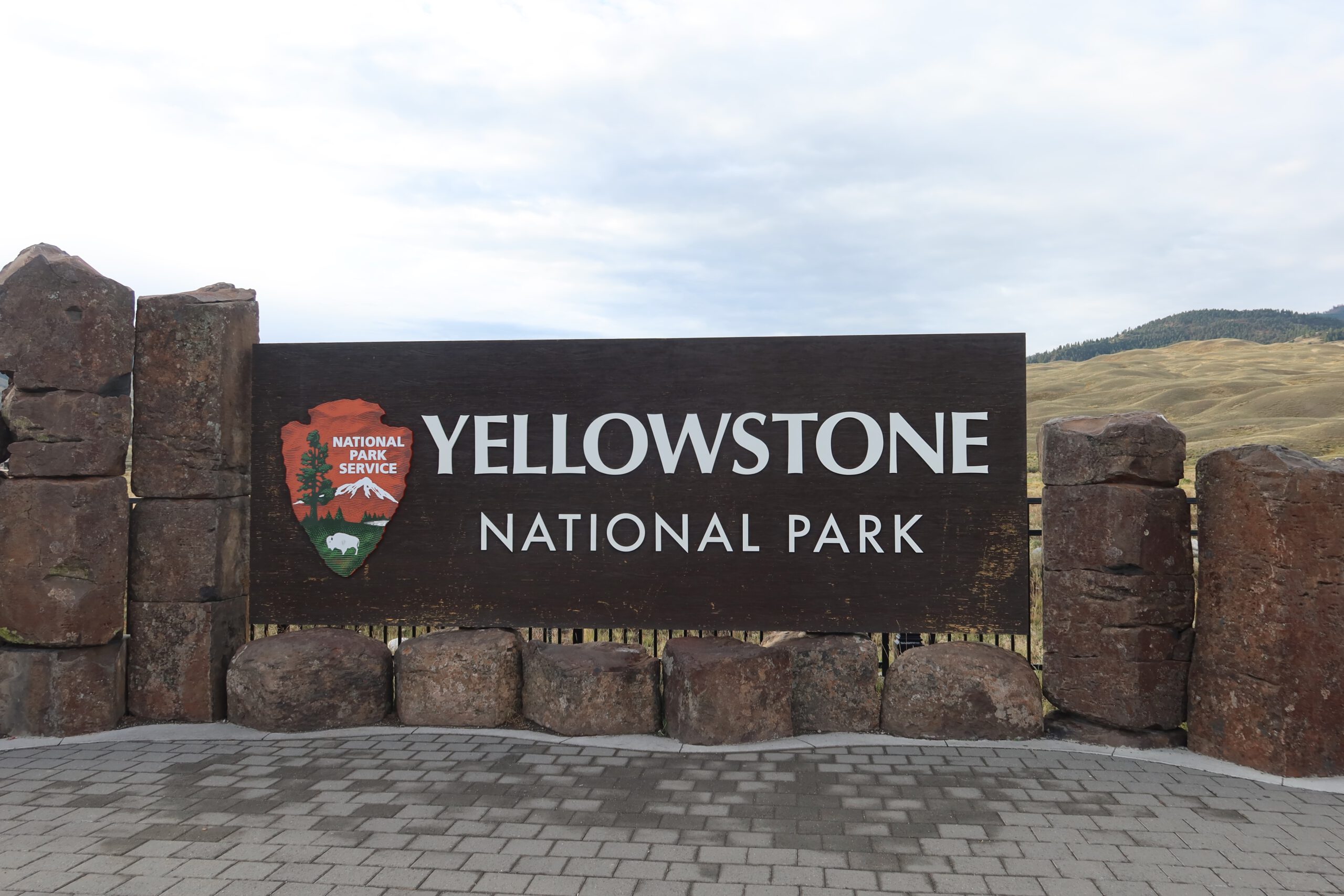 Yellowstone National Park entrance sign at the North Entrance near Gardiner Montana, official National Park Service sign with mountain landscape
