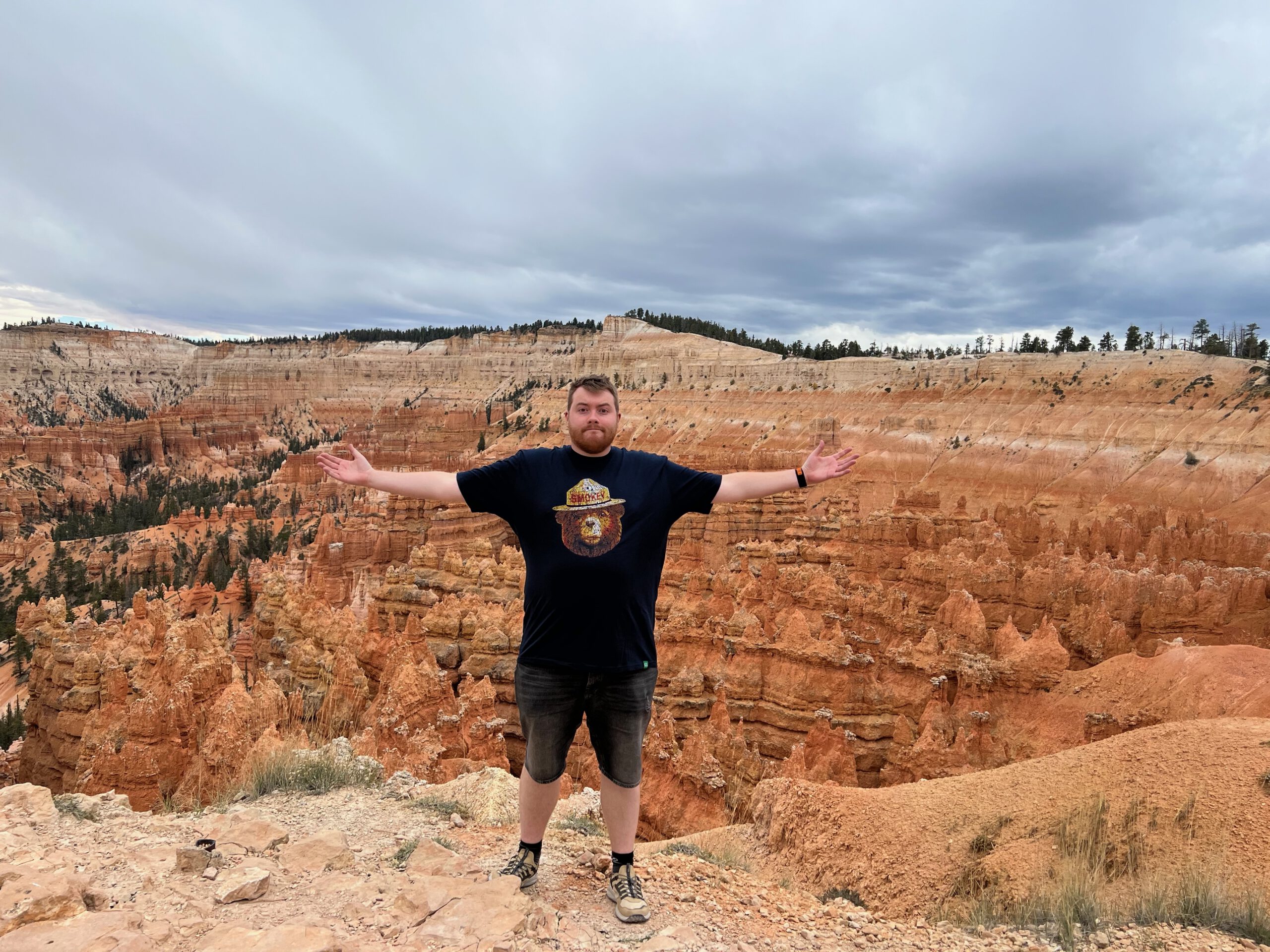 Visitor with arms wide open overlooking Bryce Canyon National Park, showcasing the vast amphitheater of orange hoodoos and rugged Utah landscape