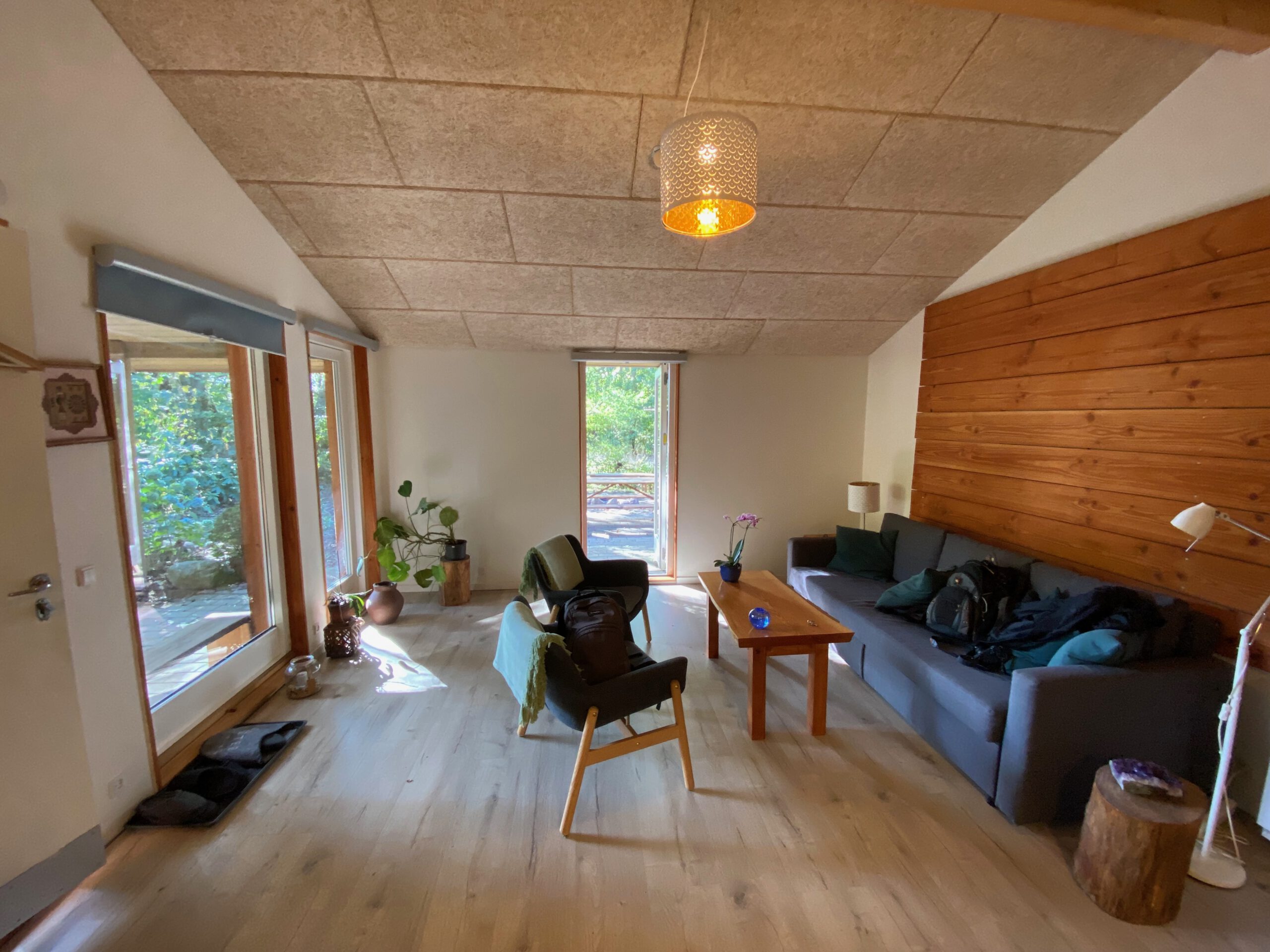 Solevad Cottage in the Forest, bright living room with seating area, wooden interior and forest view through large windows