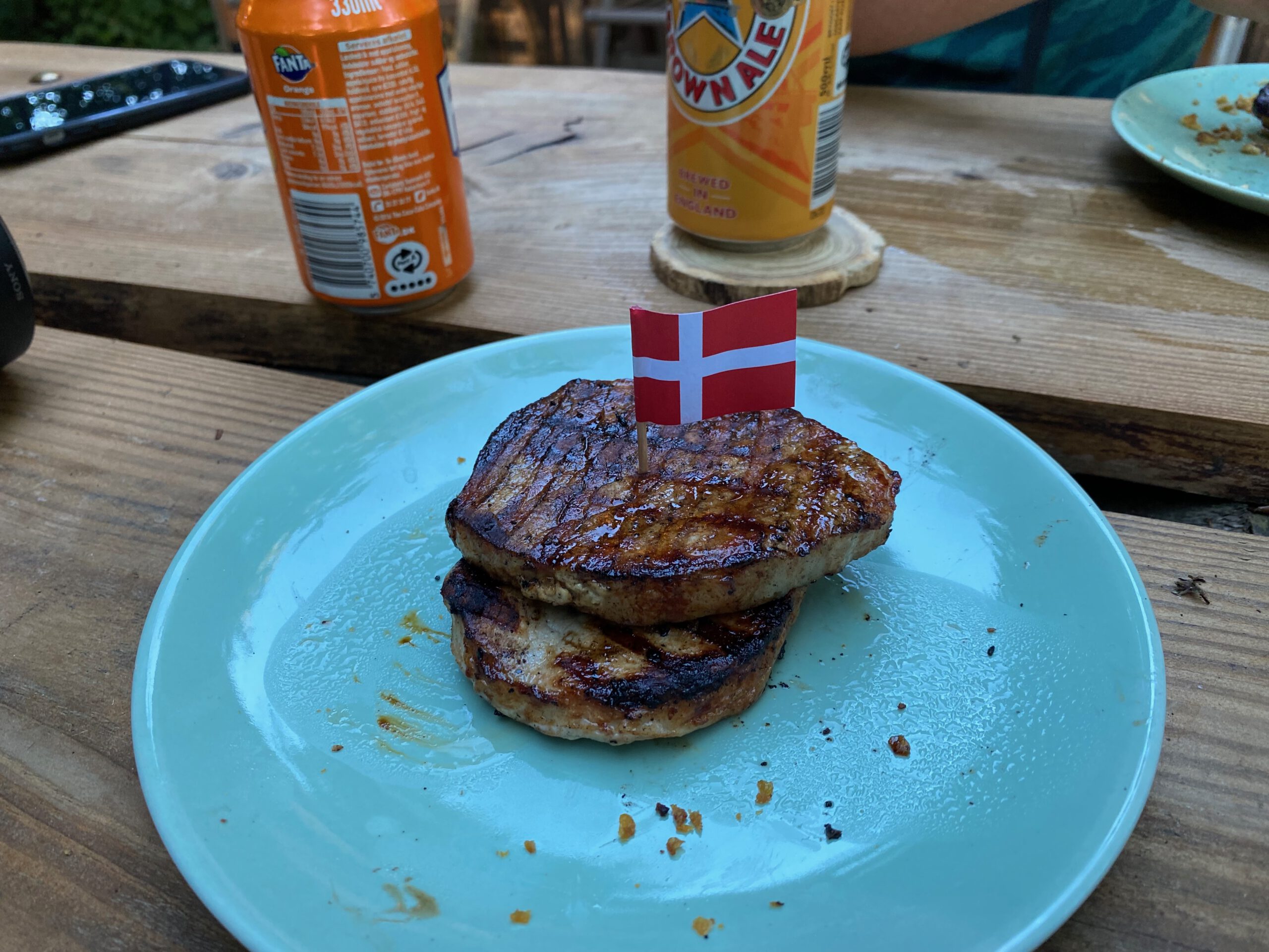 Solevad Cottage in the Forest, freshly grilled burgers served outdoors with a small Danish flag during a forest stay near Odense