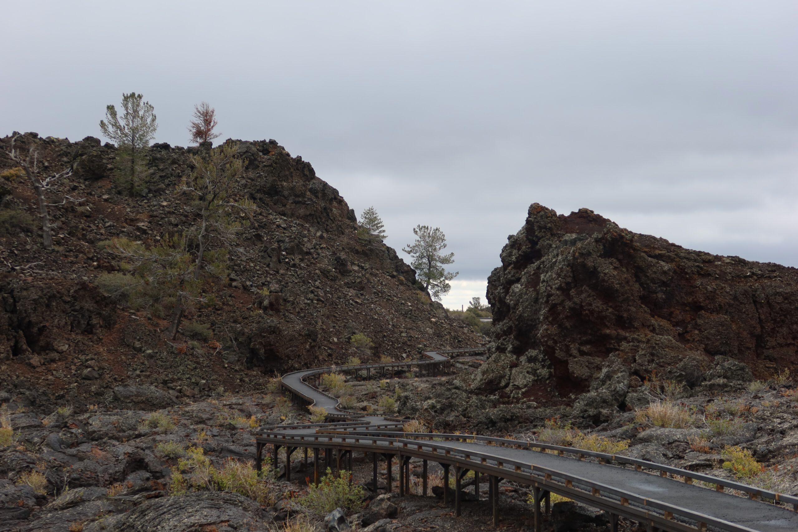 Boardwalk trail winding between volcanic rock formations at Craters of the Moon National Monument in Idaho