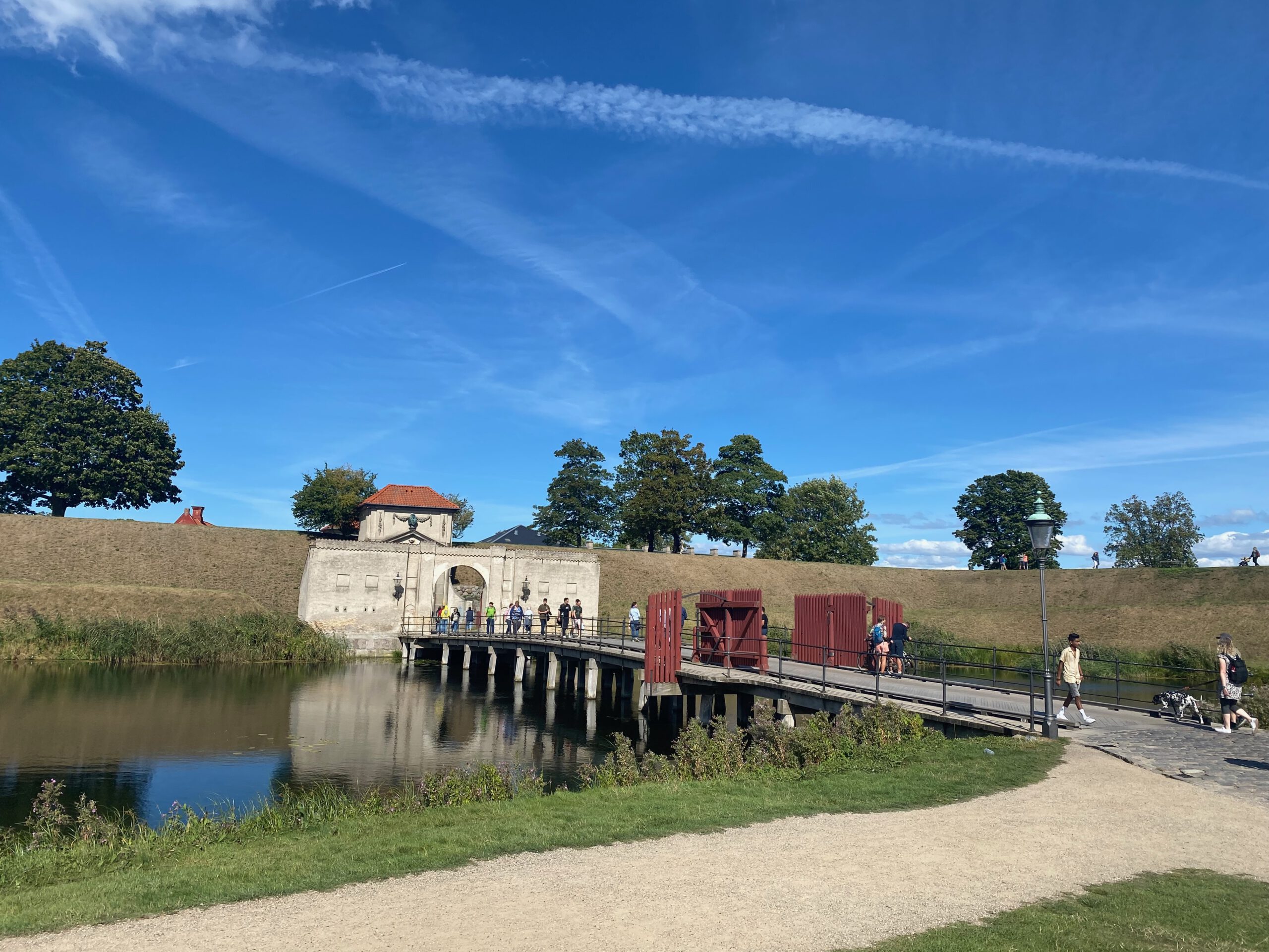 Kastellet Copenhagen entrance gate with wooden drawbridge, moat and star fortress ramparts on a sunny day