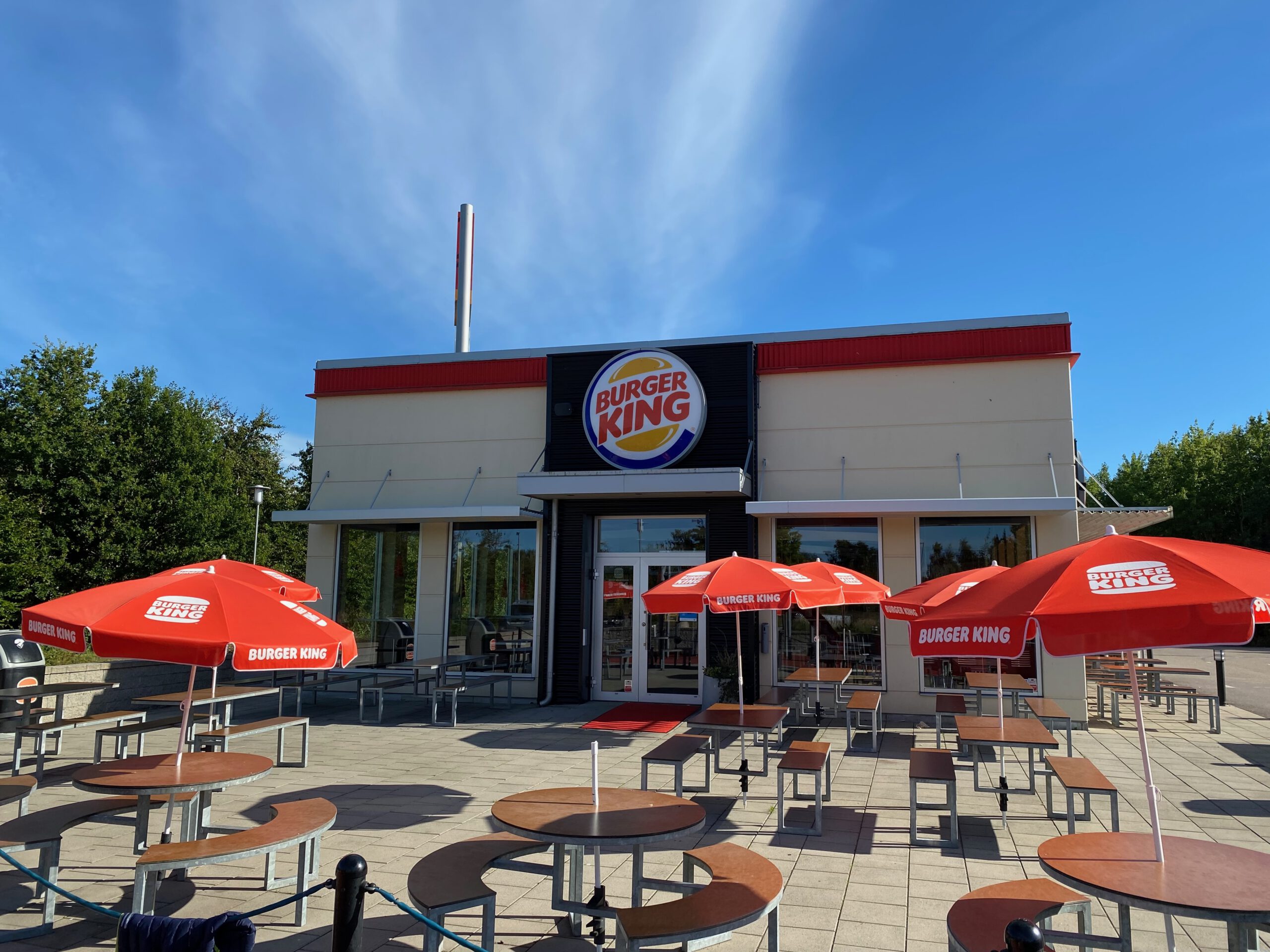 Burger King Malmö Ollebo exterior with outdoor seating and red umbrellas along the highway in southern Sweden