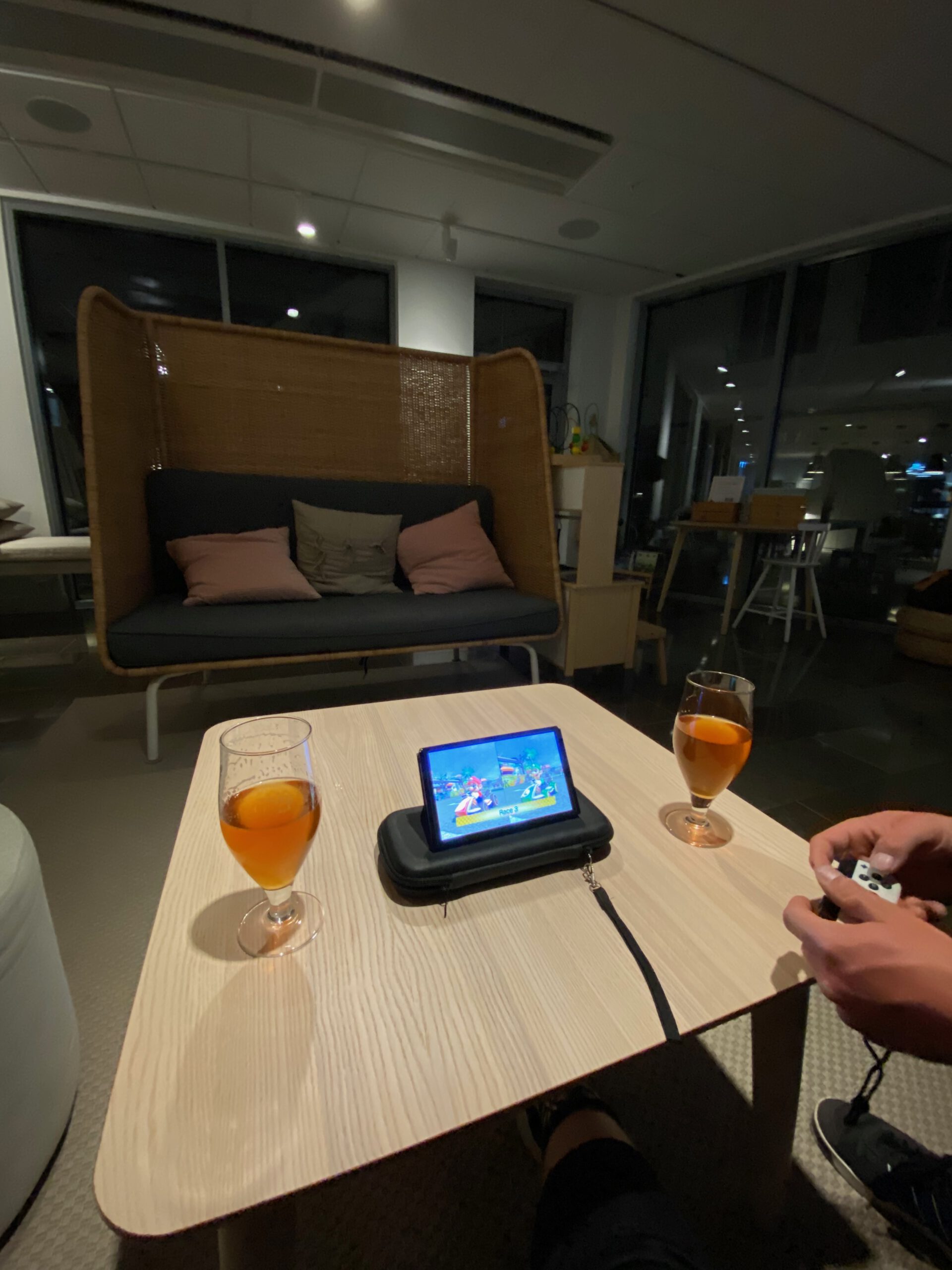Evening at IKEA Hotell Älmhult lounge with two local draft beers on a table while playing Mario Kart on a Nintendo Switch OLED, creating a relaxed and cozy hotel night atmosphere.