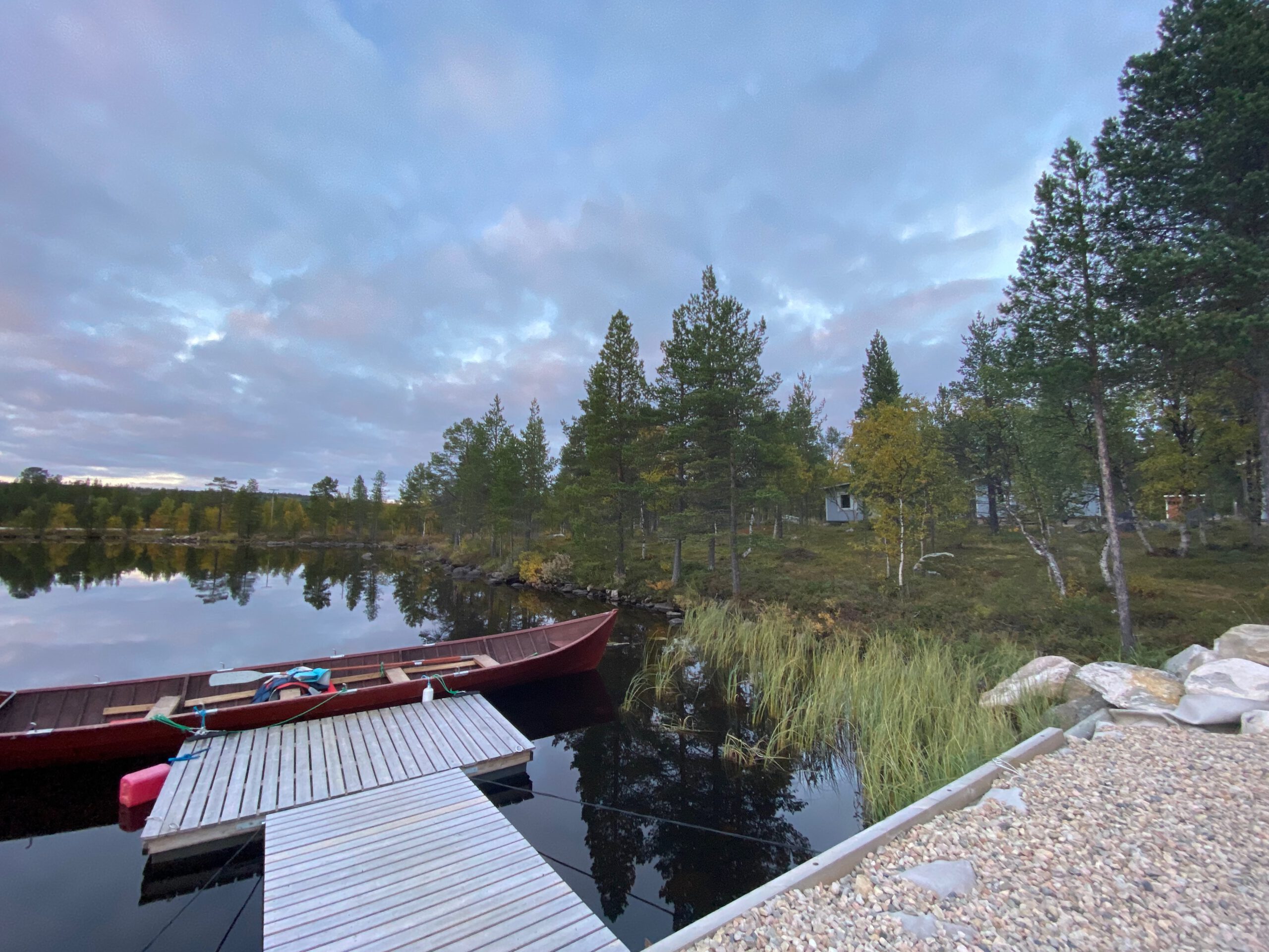Hetan Kota Enontekiö Finland wooden pier and boat on the lake, authentic Lapland wilderness setting next to the accommodation