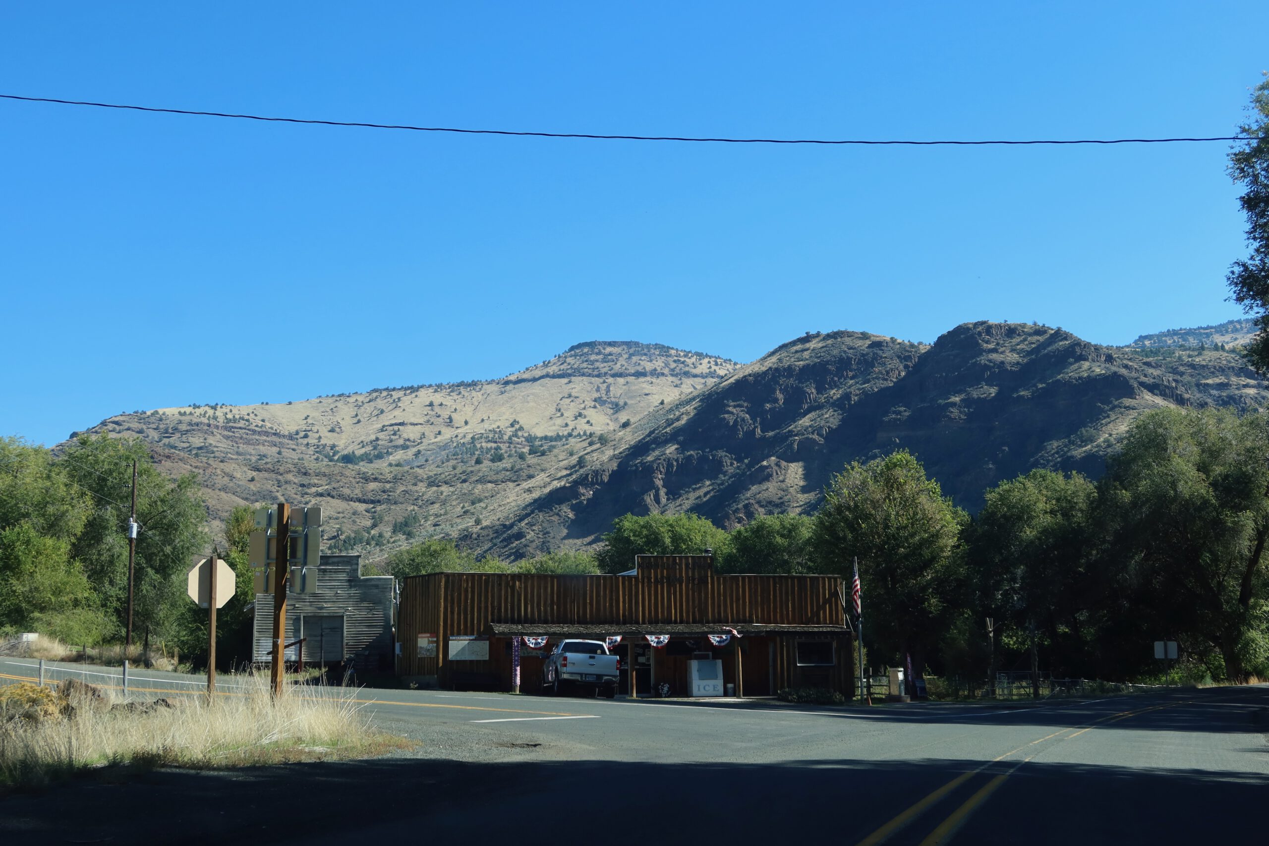 Kimberley Trading Post in rural Oregon with a wooden roadside building set against rugged hills near the John Day River