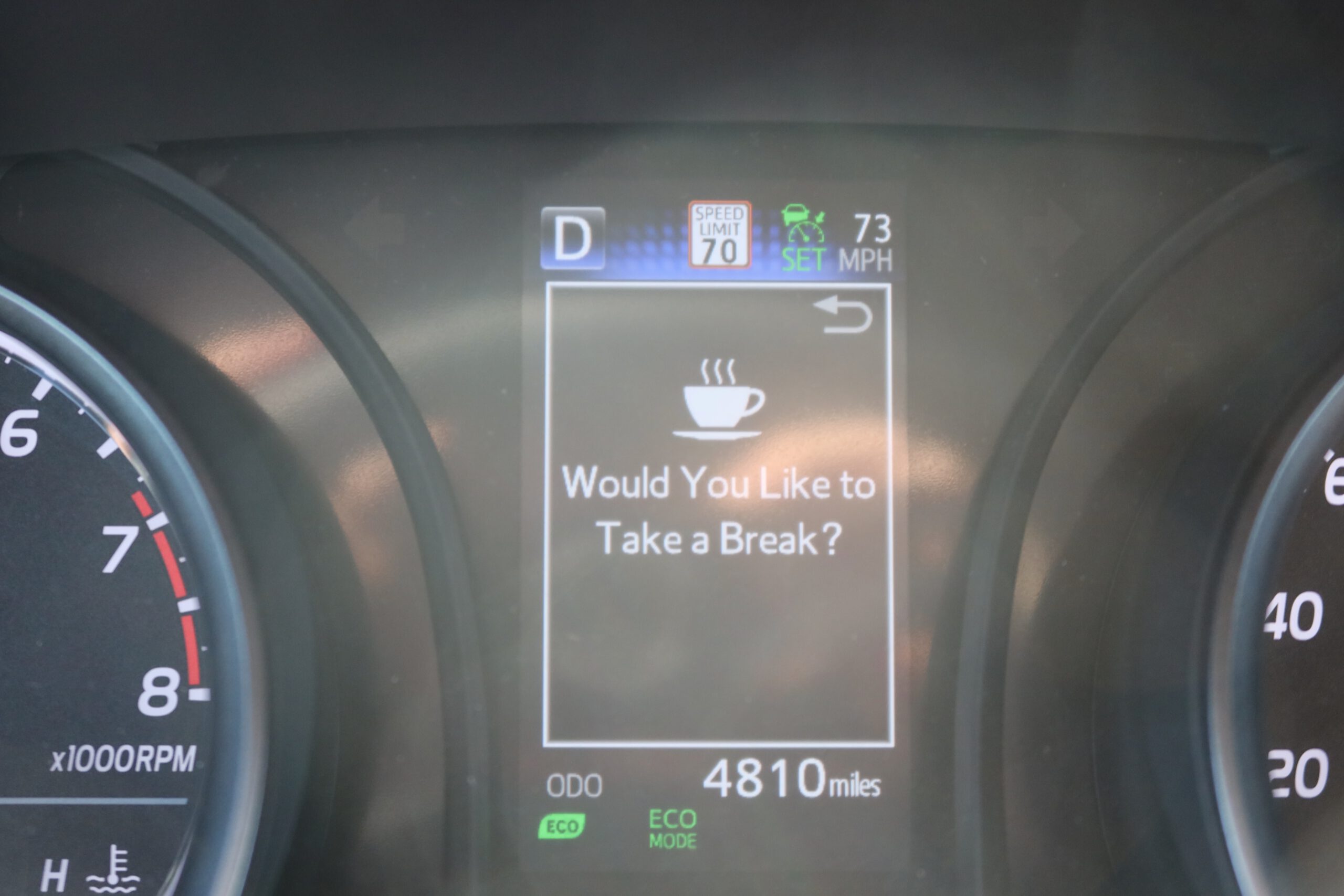 Toyota Camry 2024 dashboard showing driver alert message asking to take a break while cruising on an American highway
