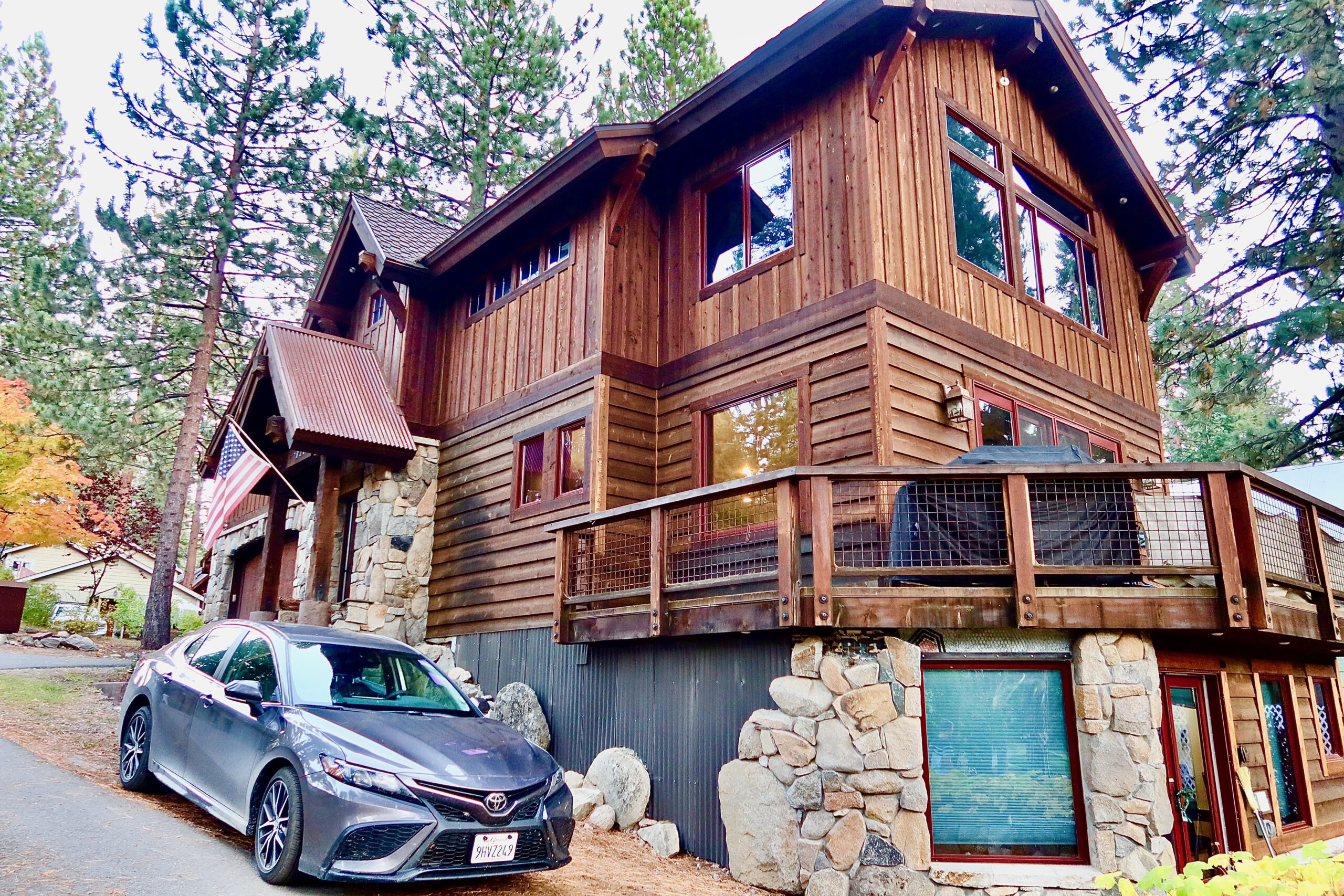 Header image of a rustic wooden cabin surrounded by pine trees in Tahoe Vista, featuring private parking and forest views as part of a Lake Tahoe studio rental in a quiet North Lake Tahoe neighborhood.