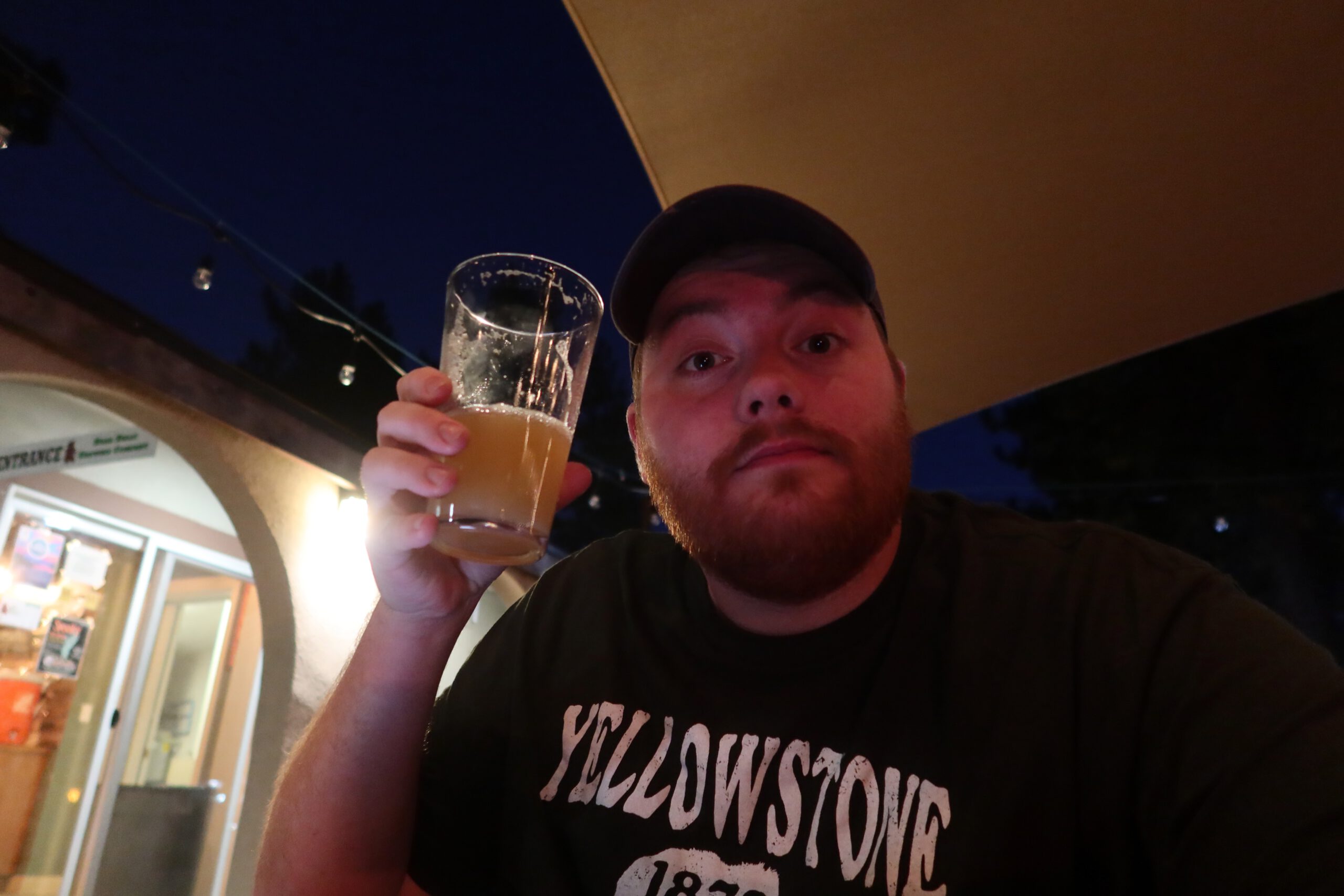 Timeuw, Timo van den Berg holding a fresh craft beer at Bear Belly Brewing Company in Kings Beach California, enjoying a relaxed evening at a local Lake Tahoe brewery in a Yellowstone t-shirt
