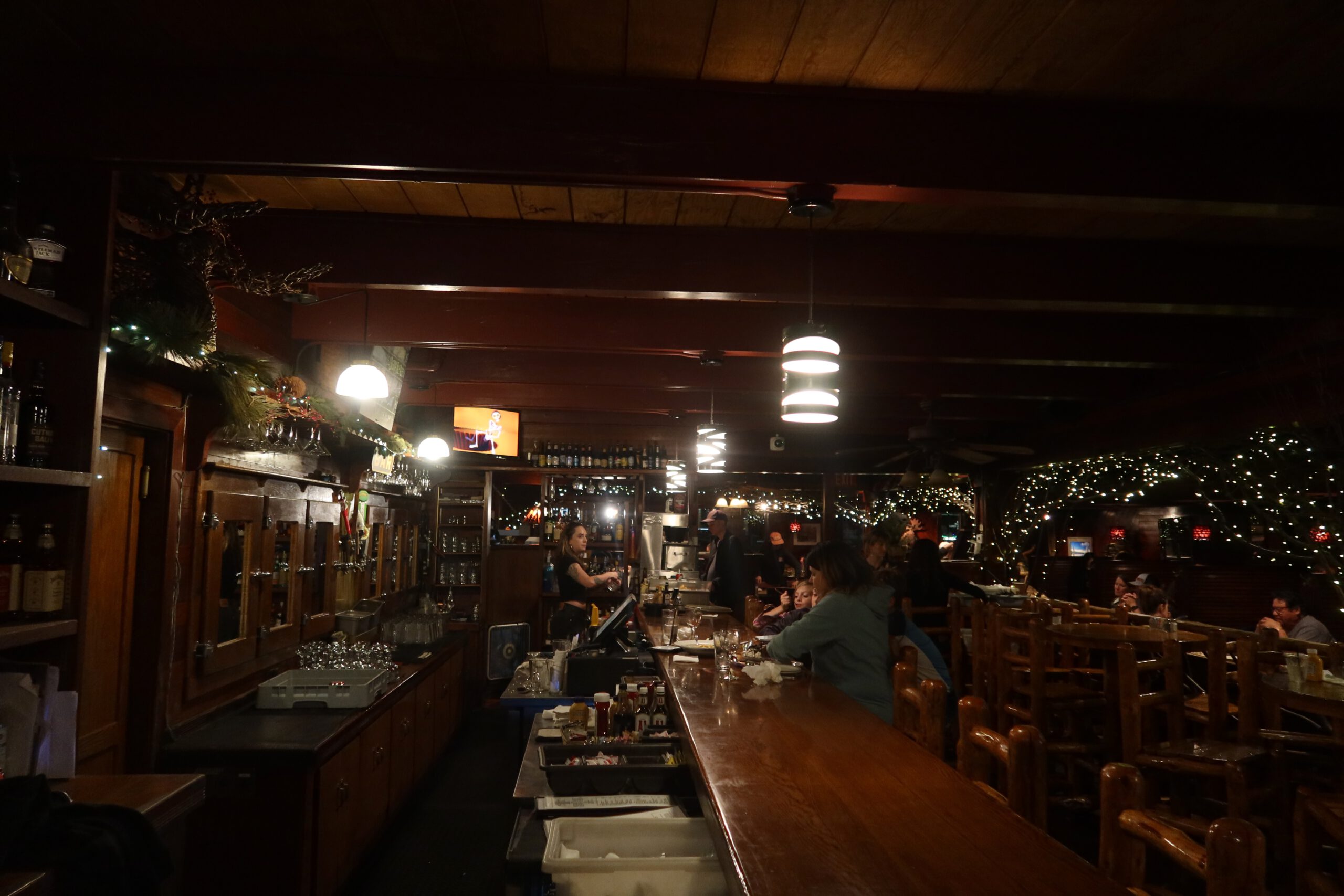 Warm evening atmosphere inside Jason’s Beachside Grille with wooden bar and dining area, a well known restaurant close to the lake and a Lake Tahoe studio rental in Tahoe Vista.