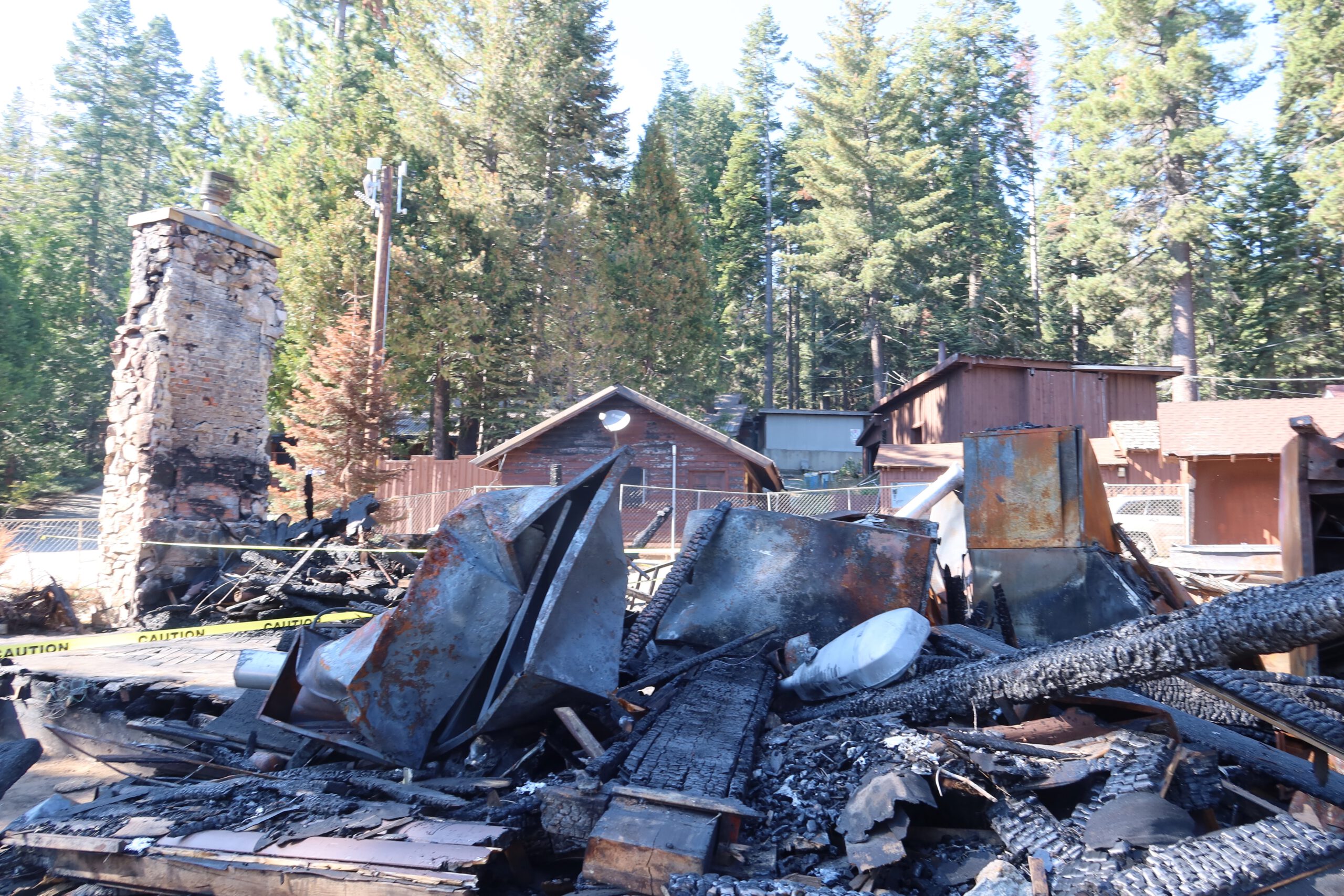 Fire damage remains at Bear River Lake Resort in Amador County, California, showing collapsed structures, burned debris, and the stone chimney after the main lodge fire
