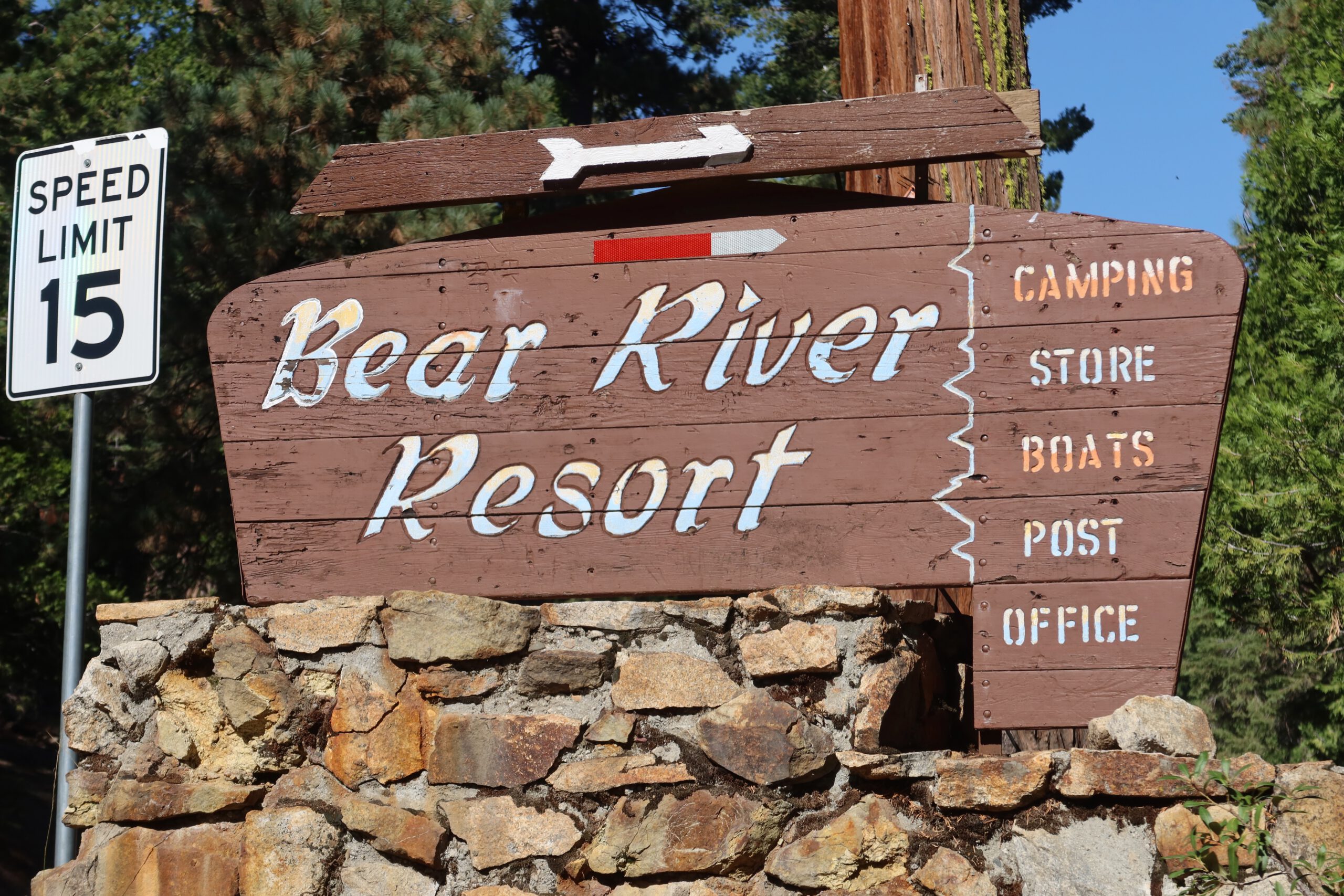 Wooden Bear River Resort entrance sign along Highway 88 in Amador County, California, showing directions to camping, store, boats, and post office