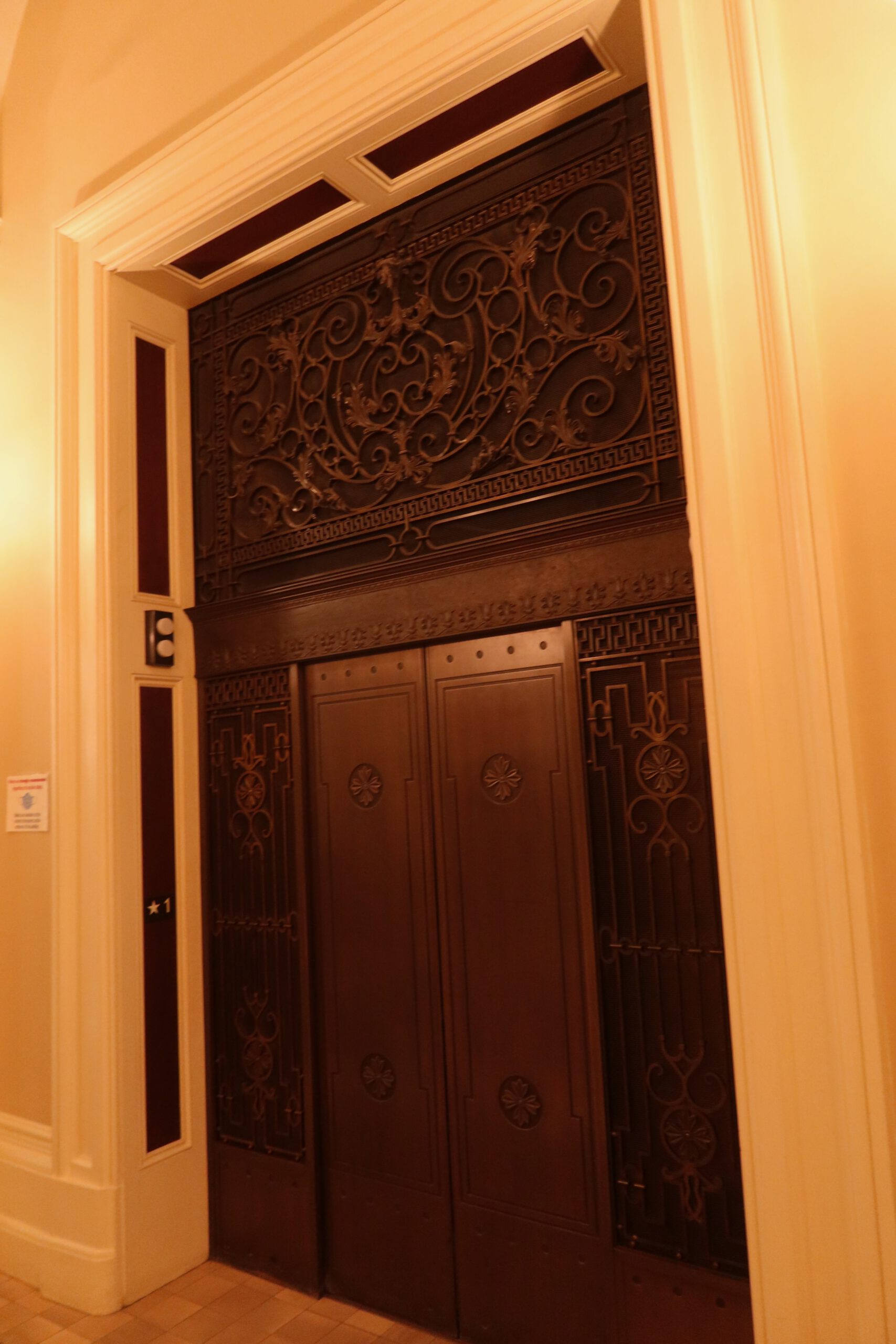 Historic elevator doors inside the California State Capitol Museum, featuring ornate wrought iron metalwork, classical patterns, and warm interior lighting reflecting the building’s nineteenth century architecture.