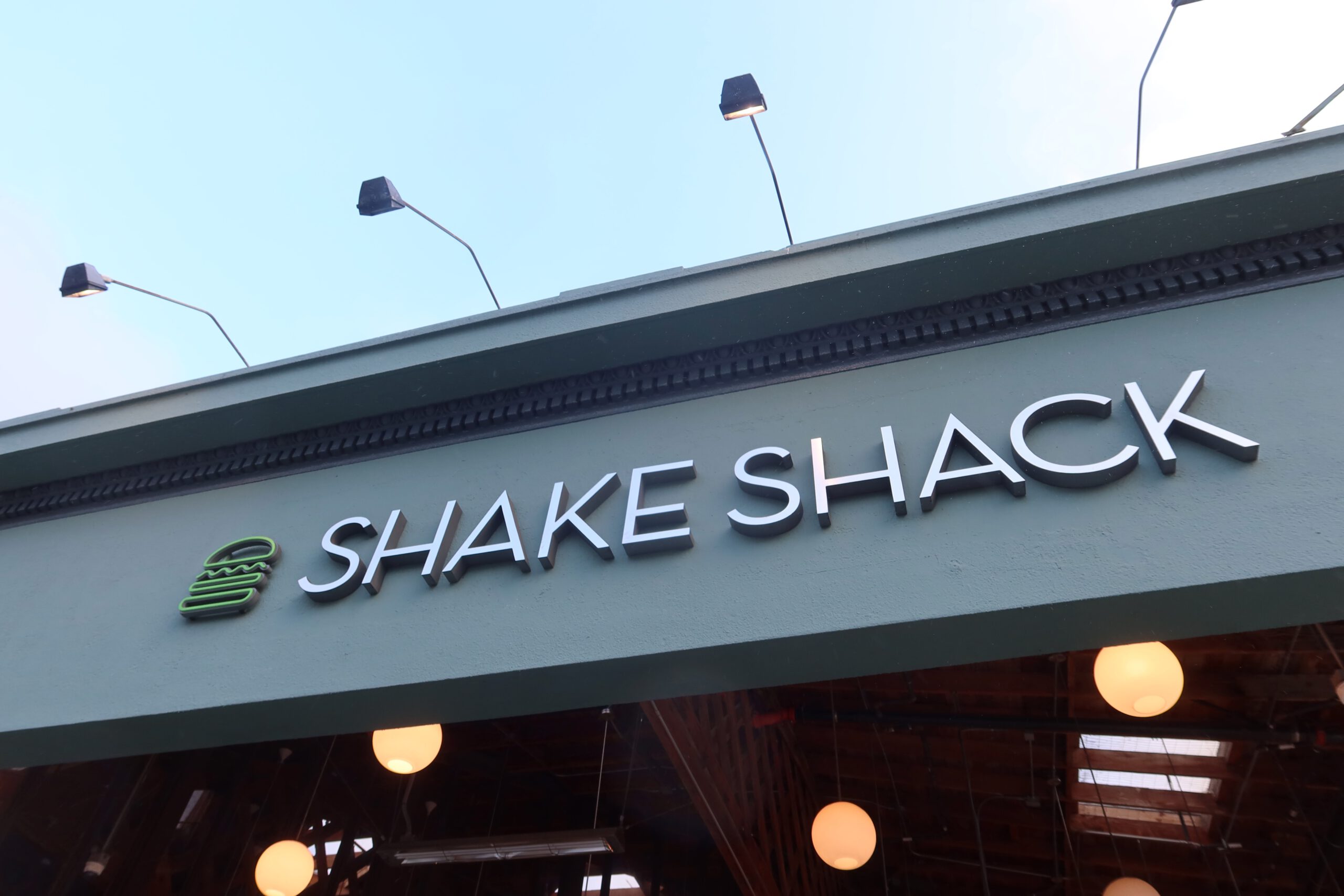 Shake Shack Cow Hollow San Francisco exterior sign with green facade, modern lighting, and iconic Shake Shack logo