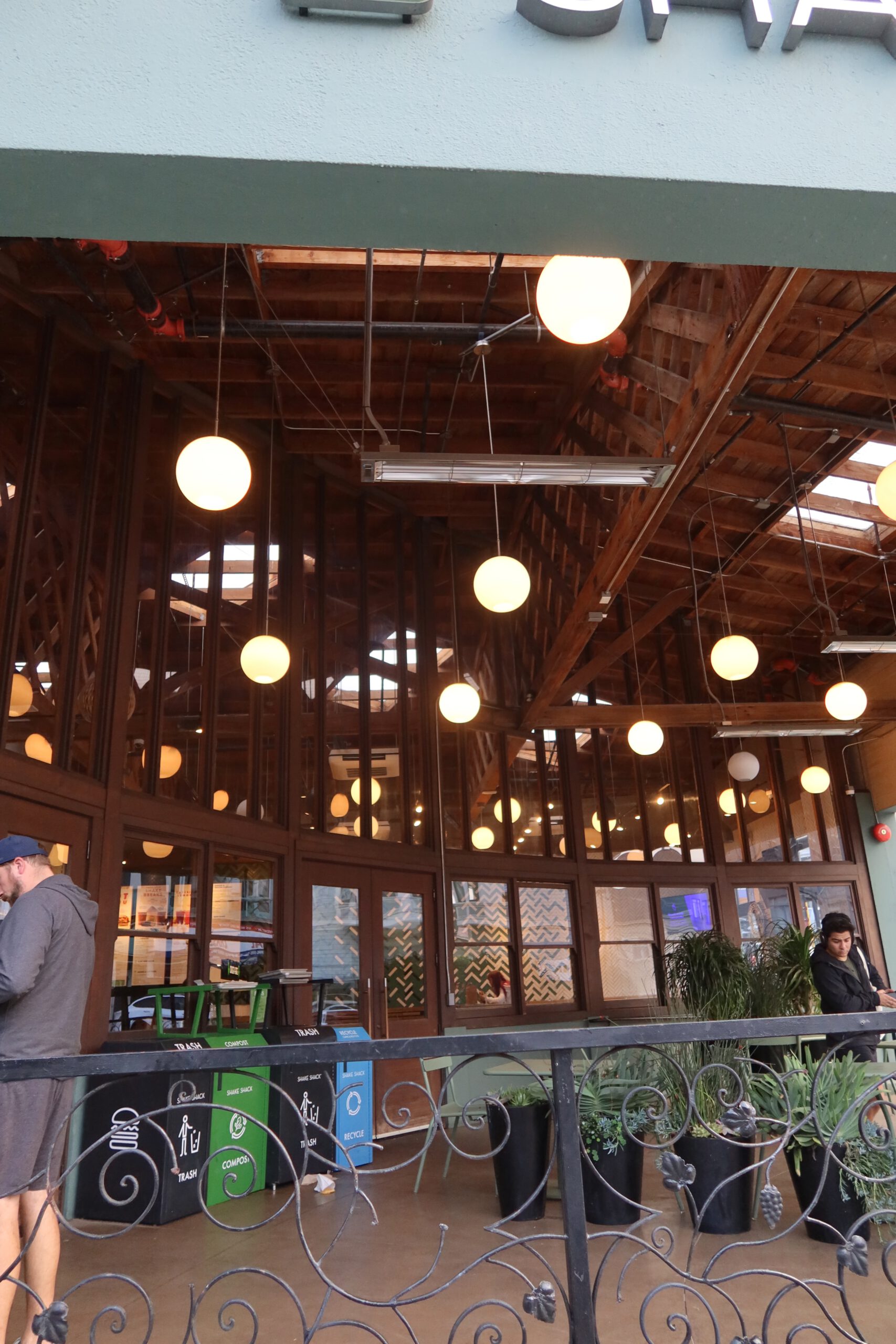 Interior of Shake Shack Cow Hollow San Francisco with wooden ceiling, warm hanging lights, and open seating area