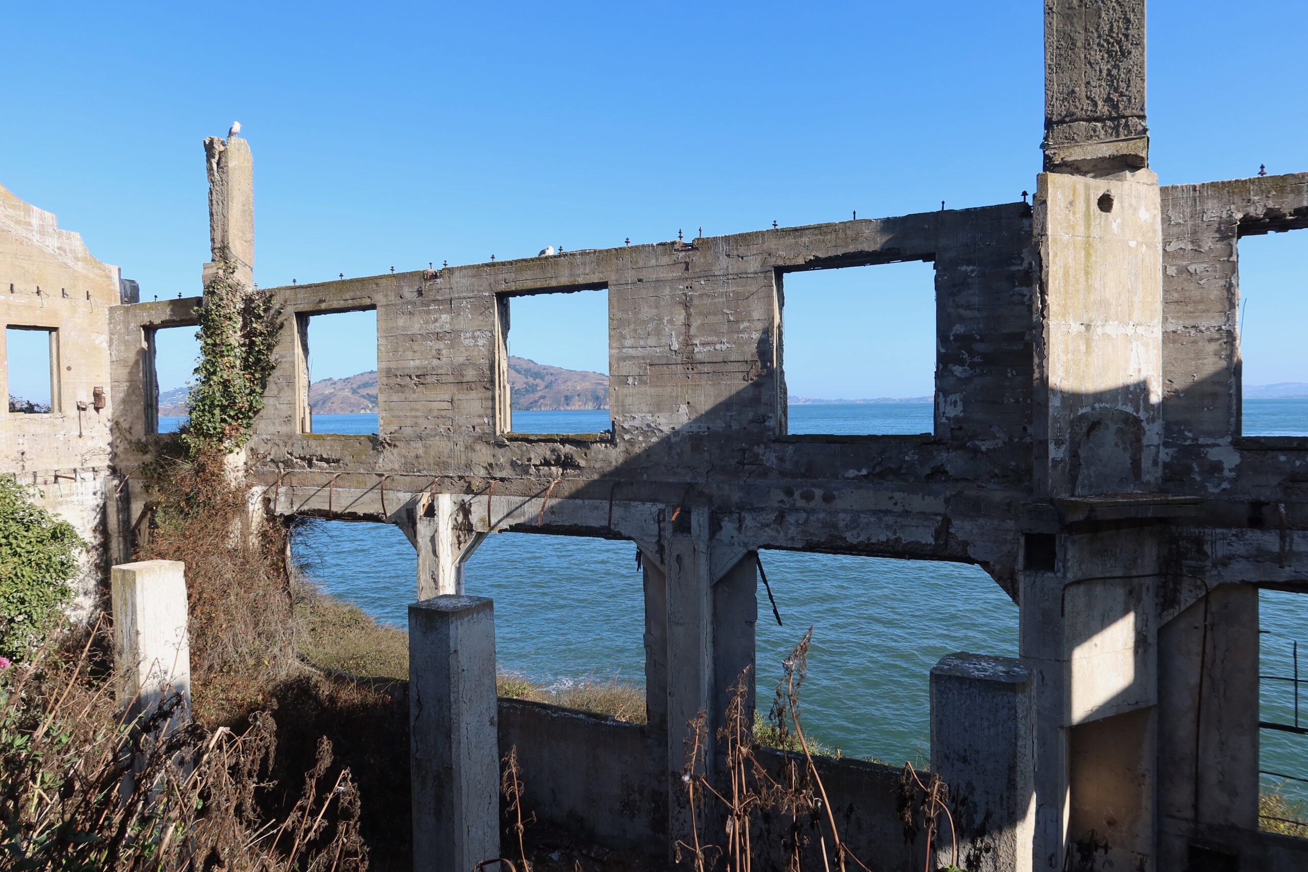 Alcatraz Island ruins with open concrete window frames facing San Francisco Bay, historic prison structures exposed to the elements
