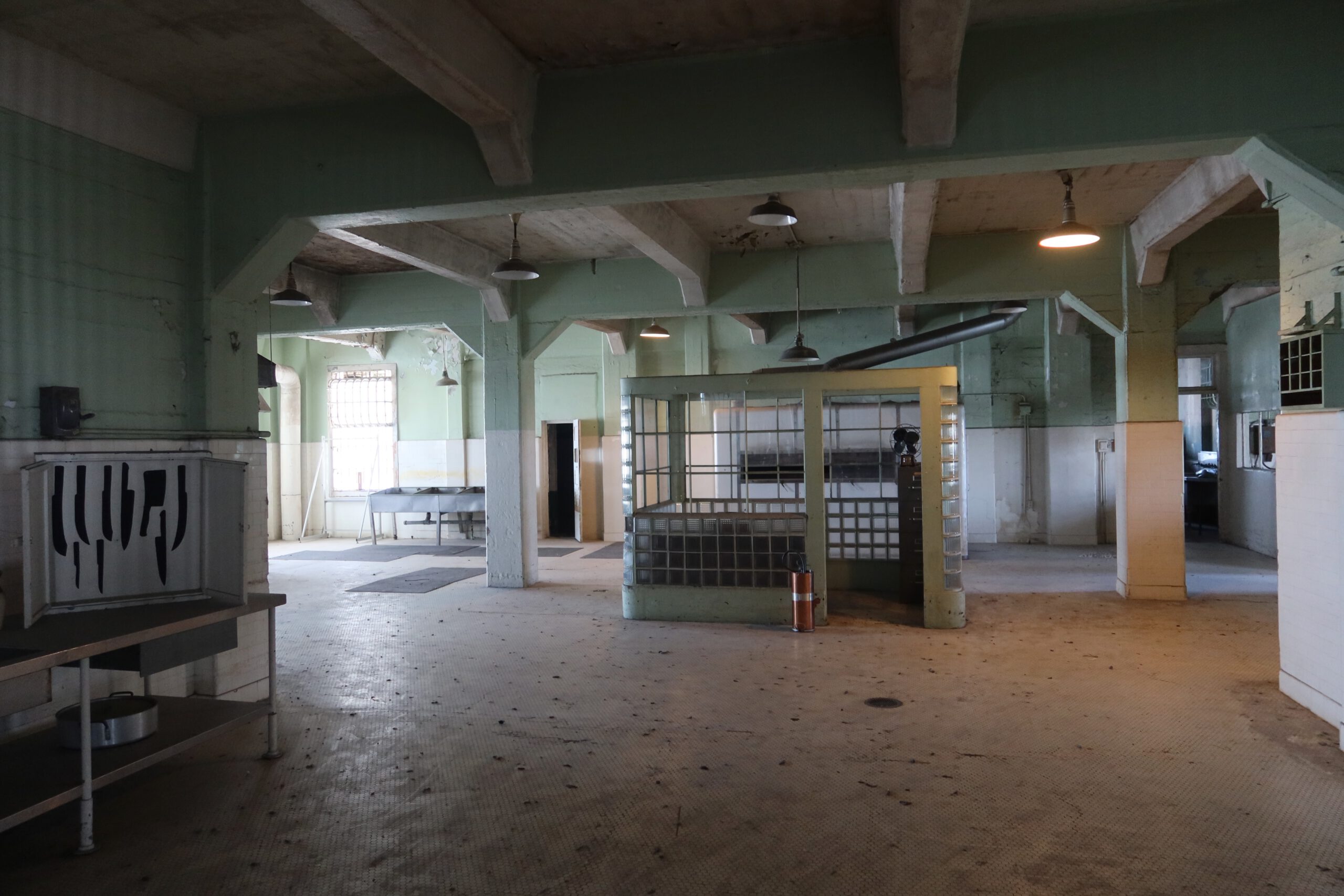 Interior of the Alcatraz Island prison kitchen showing original layout, tiled floors, support columns and industrial lighting