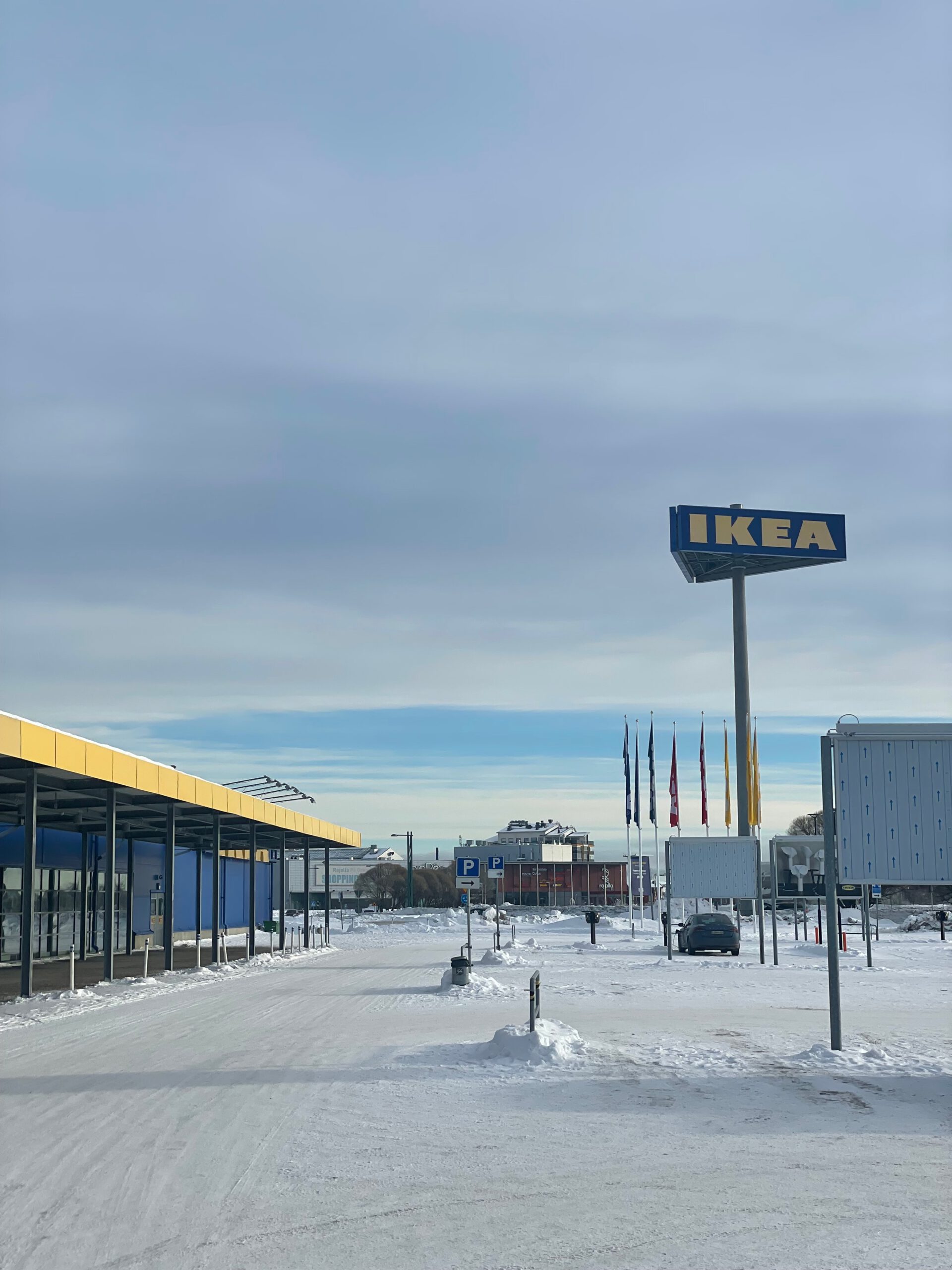 IKEA Haparanda Restaurant and Store exterior in winter, wide view of the parking area with snow, flags and the iconic IKEA sign at the northernmost IKEA in the world