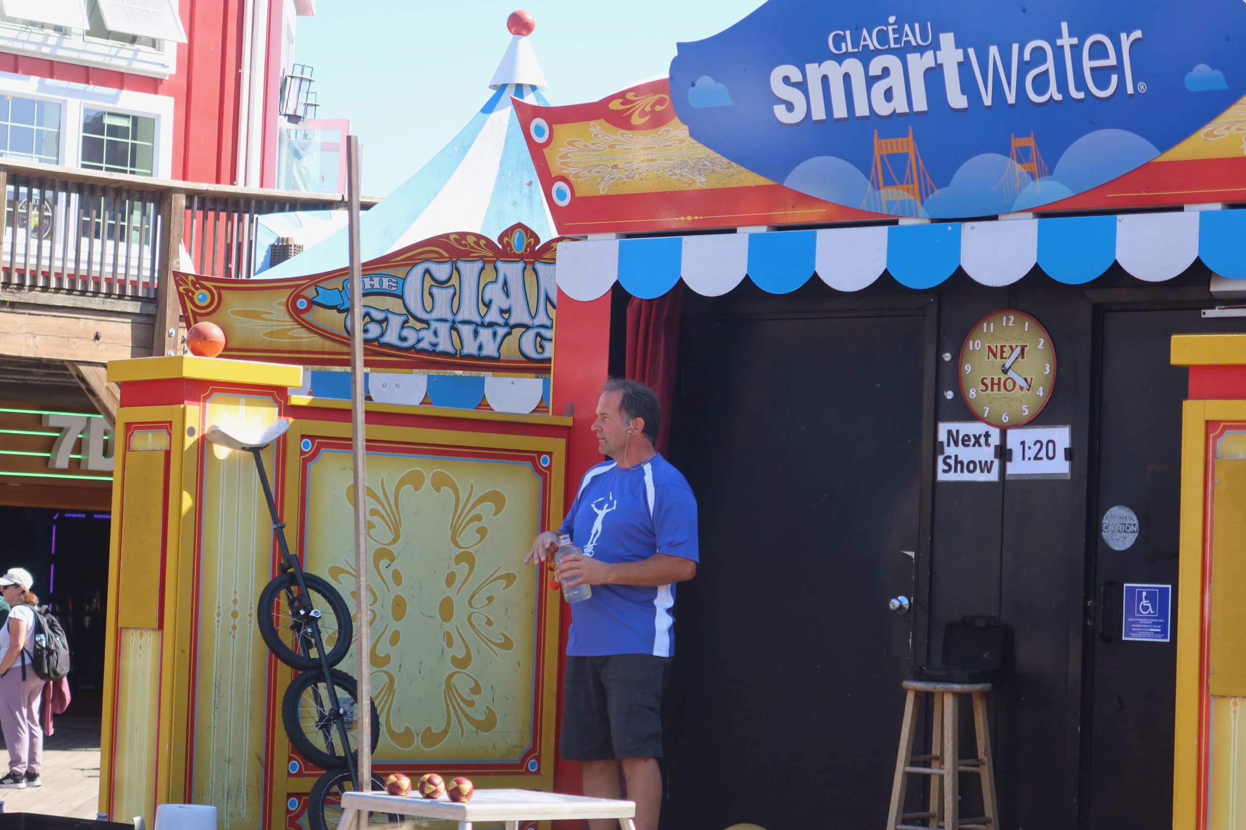 Bob At Large Pier 39 San Francisco performing his interactive street show, Bob At Large talking to the crowd in front of his colorful stage with juggling props and unicycle at the Pier 39 waterfront