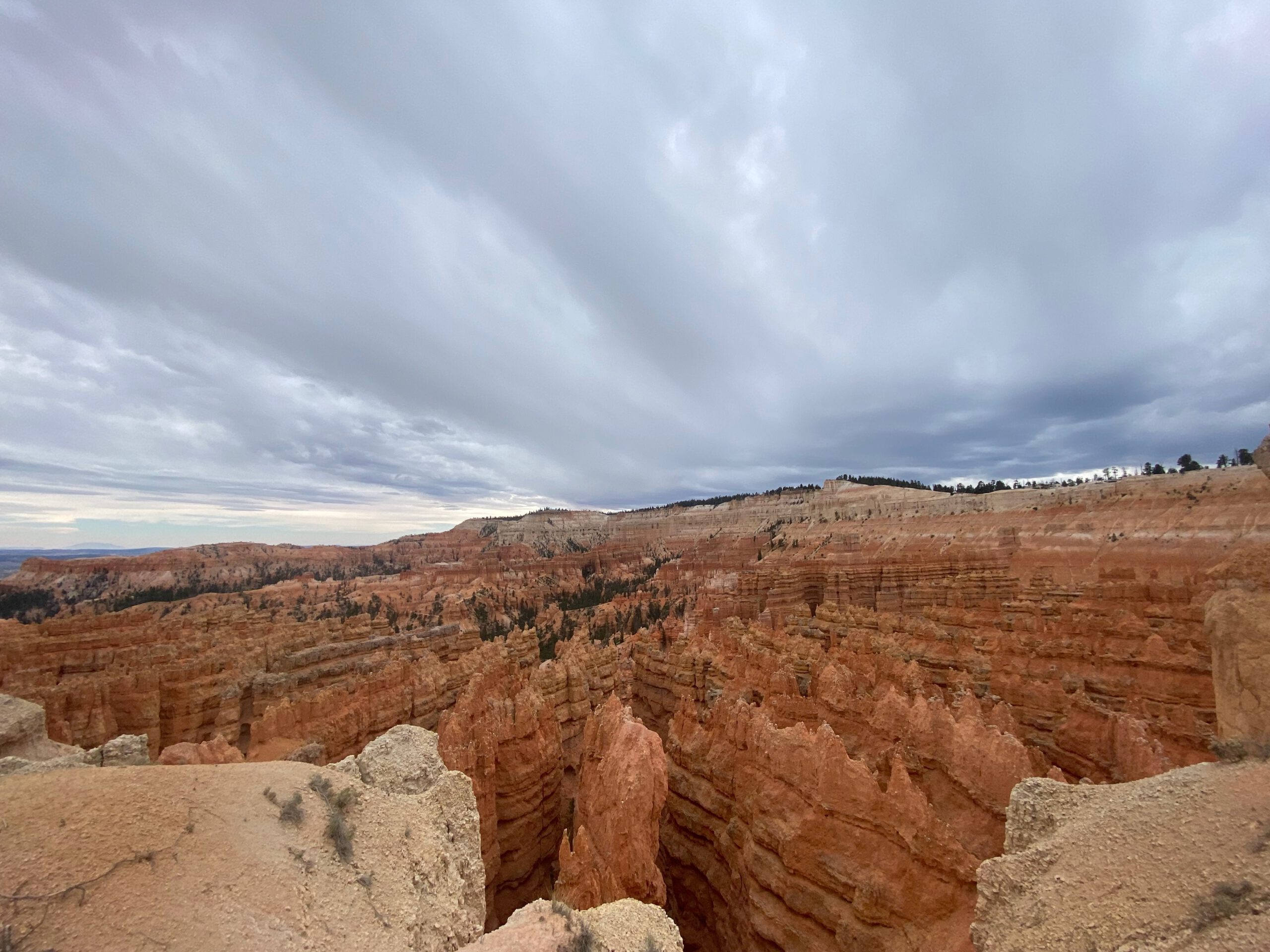 Scenic overlook in Bryce Canyon National Park featuring towering hoodoos, rugged canyon edges, and moody clouds above Utah’s high desert