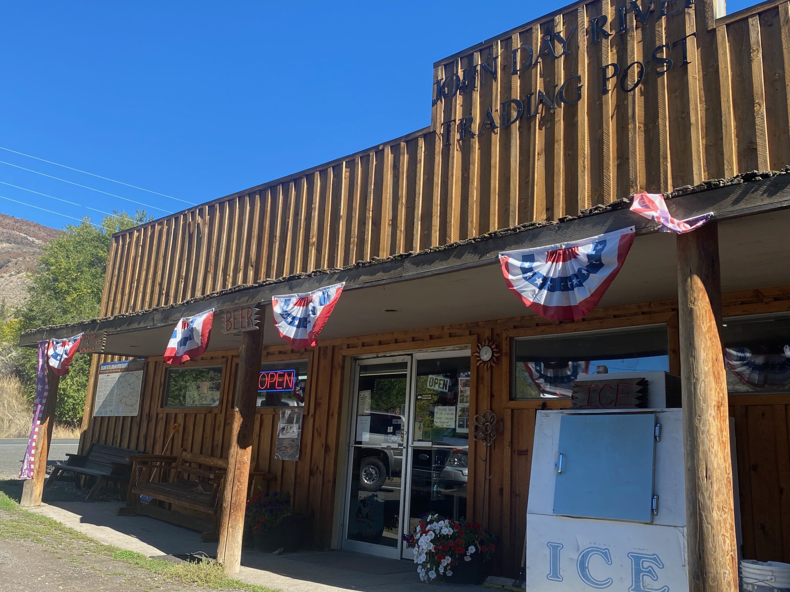 Front view of the Kimberley Trading Post in Oregon, a classic wooden Western-style store with American decorations along the road