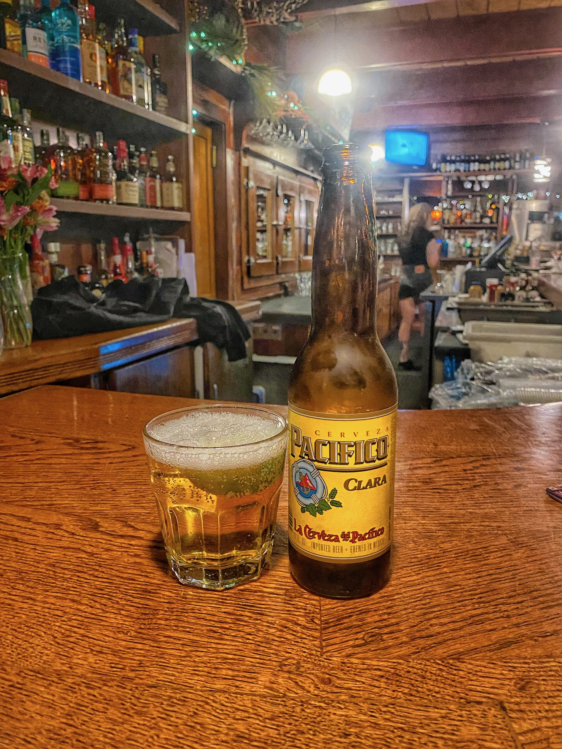 Going out in Lake Tahoe with a Pacifico Clara beer served at a wooden bar in Kings Beach, capturing a relaxed American bar atmosphere with casual evening drinks