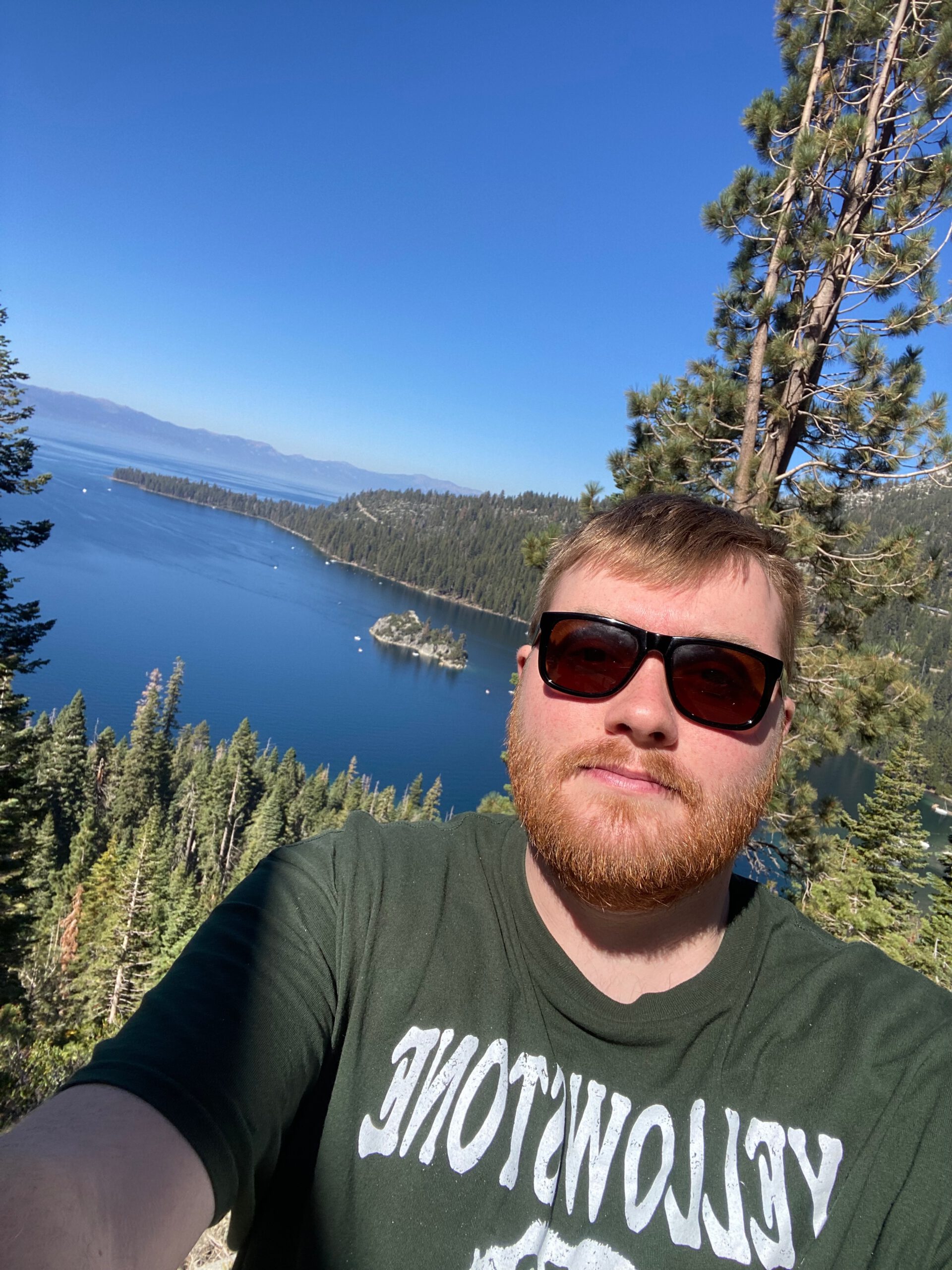 Traveler enjoying a scenic overlook at Lake Tahoe after a night out, capturing the iconic blue water and forested islands with a relaxed Tahoe hangover vibe.
