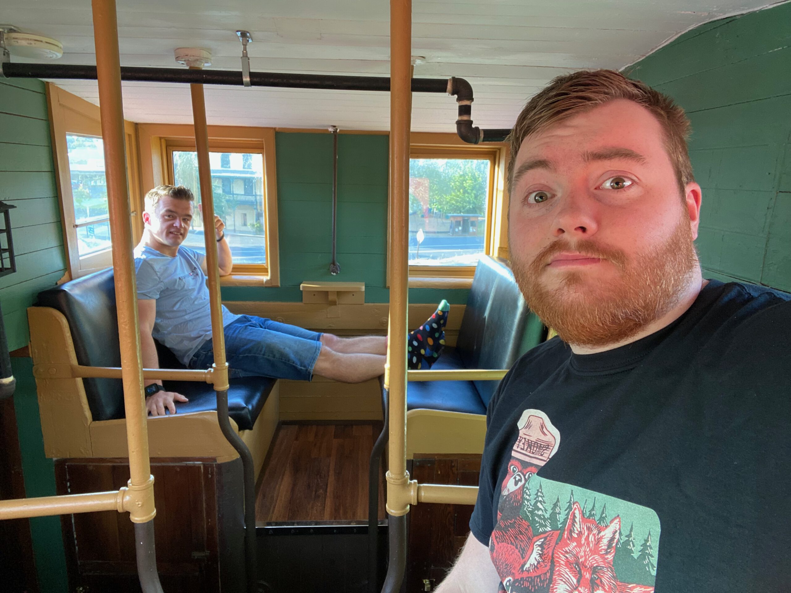 Inside the Vacation Station caboose in Coulterville California, travelers relaxing on original train seating, unique Airbnb interior near Yosemite National Park. Timeuw , Timo van den Berg , and Peter Smit are relaxing