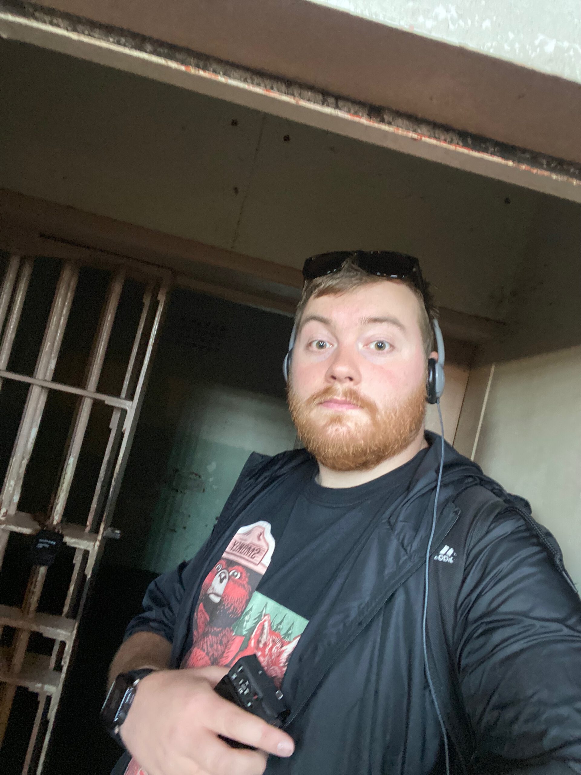 Visitor standing inside an original prison cell corridor on Alcatraz Island during the audio guided Cell House tour