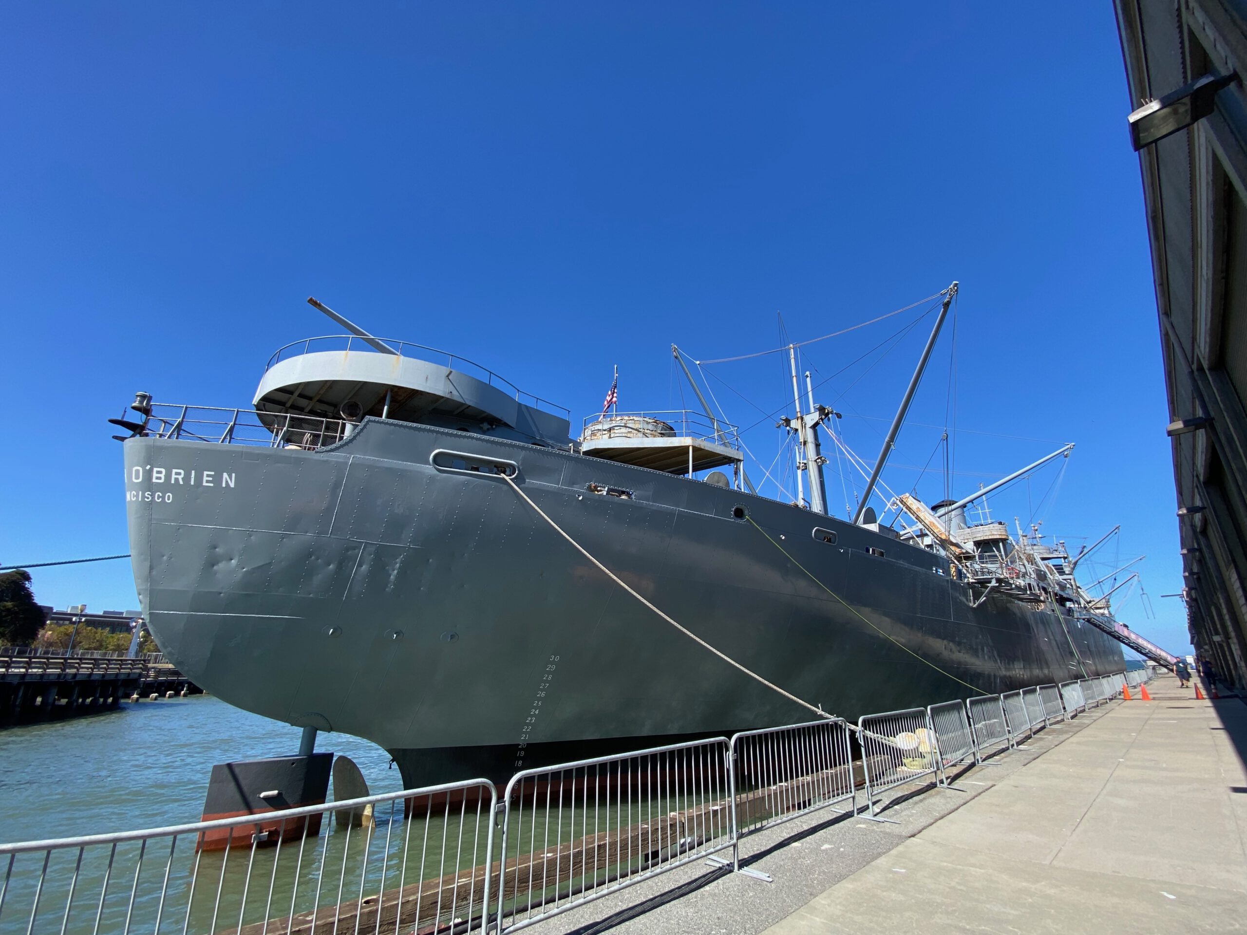 SS Jeremiah O'Brien World War II Liberty ship docked at Pier 35 in San Francisco, historic US cargo vessel viewed from the waterfront under a clear blue sky