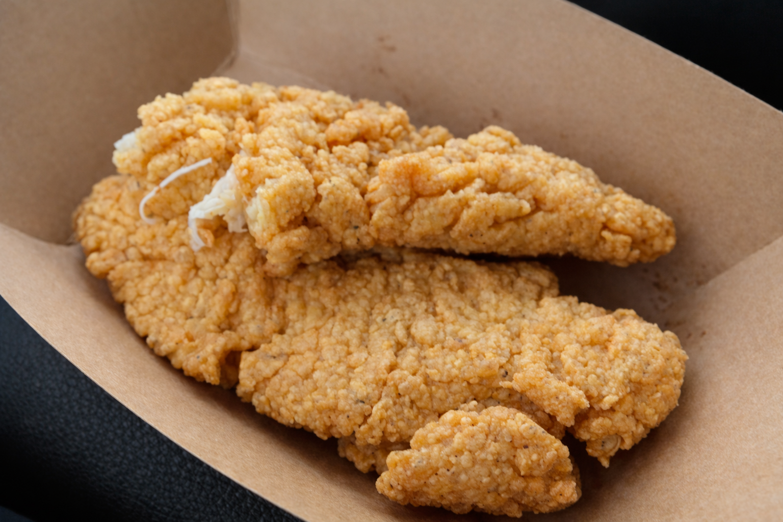 Crispy chicken tenders from the Bear Den Restaurant at Daniel Junction Wyoming, served as a classic roadside snack during a Wyoming road trip