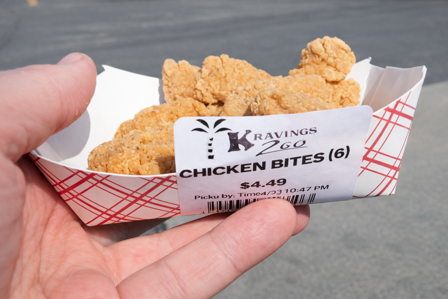 Close-up of freshly fried chicken bites from Kravings 2 Go, served in a paper tray at a roadside gas station in rural Idaho, a quick and satisfying snack for travelers on a long road trip.