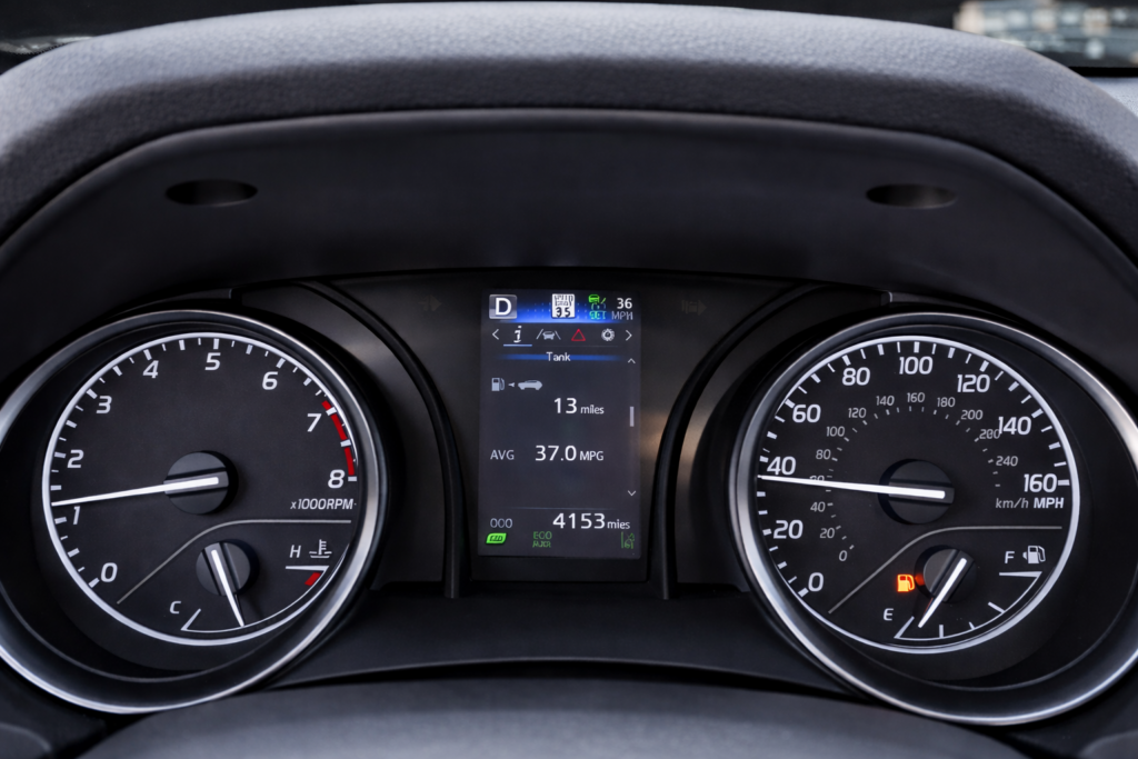 Car dashboard showing a nearly empty fuel tank with low range remaining, highlighting the risk of running out of gas while driving through remote areas of Idaho.