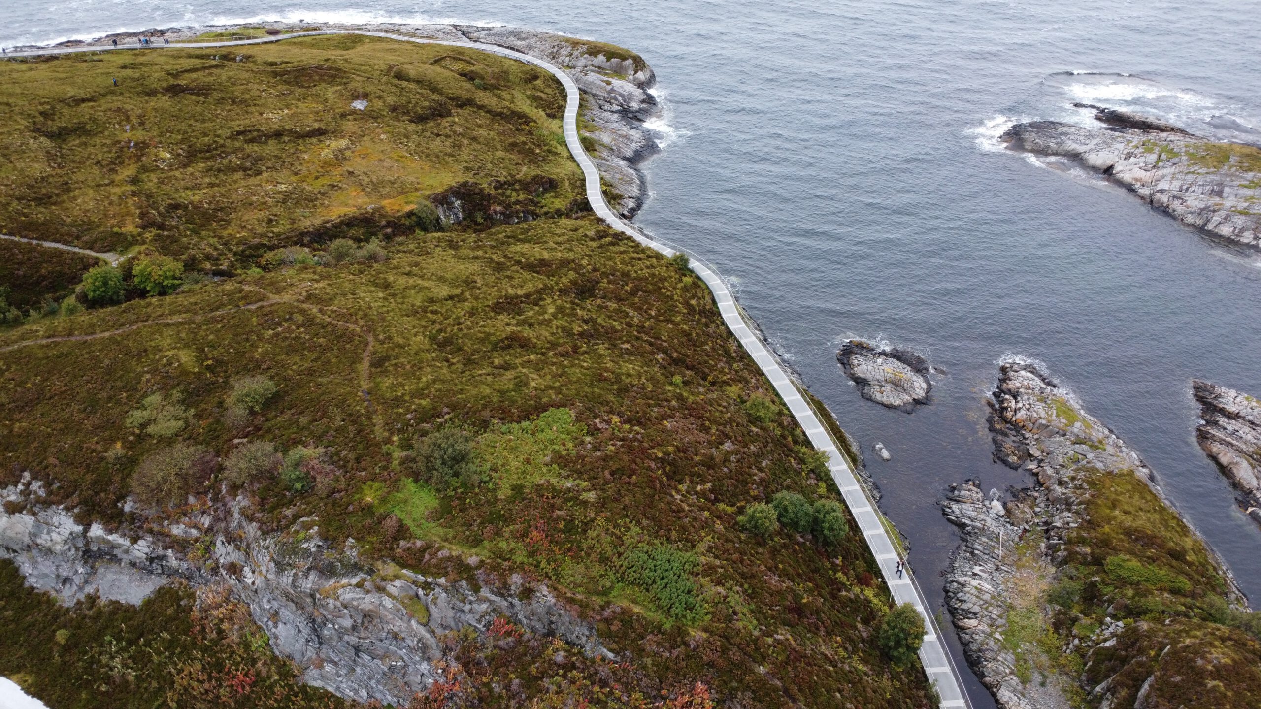 Aerial view of Atlantic Ocean Road Norway coastal walking path winding along rocky shoreline in Western Norway