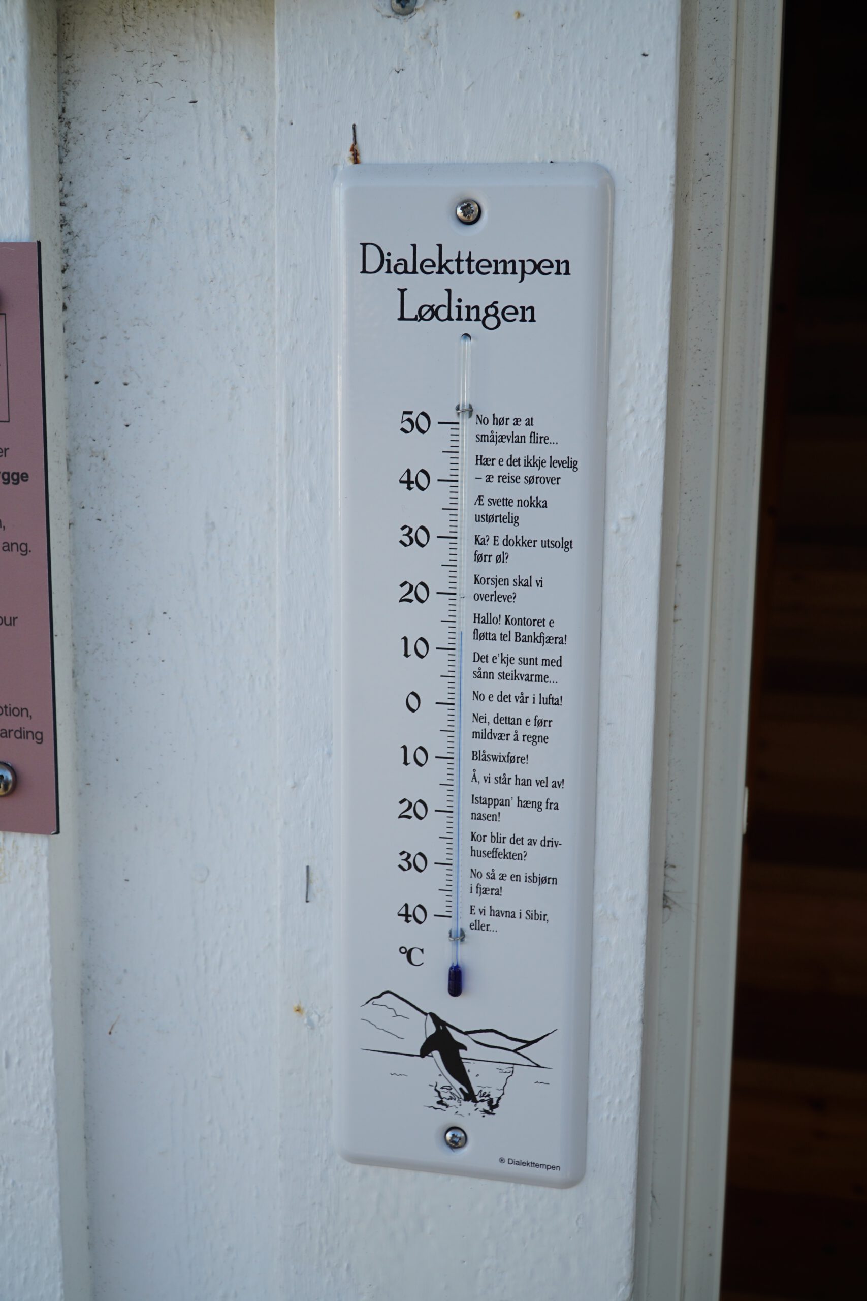 Dialekttempen thermometer in Lødingen near Lødingen Brygge Hotel Norway, local Norwegian dialect text displayed on an outdoor temperature gauge