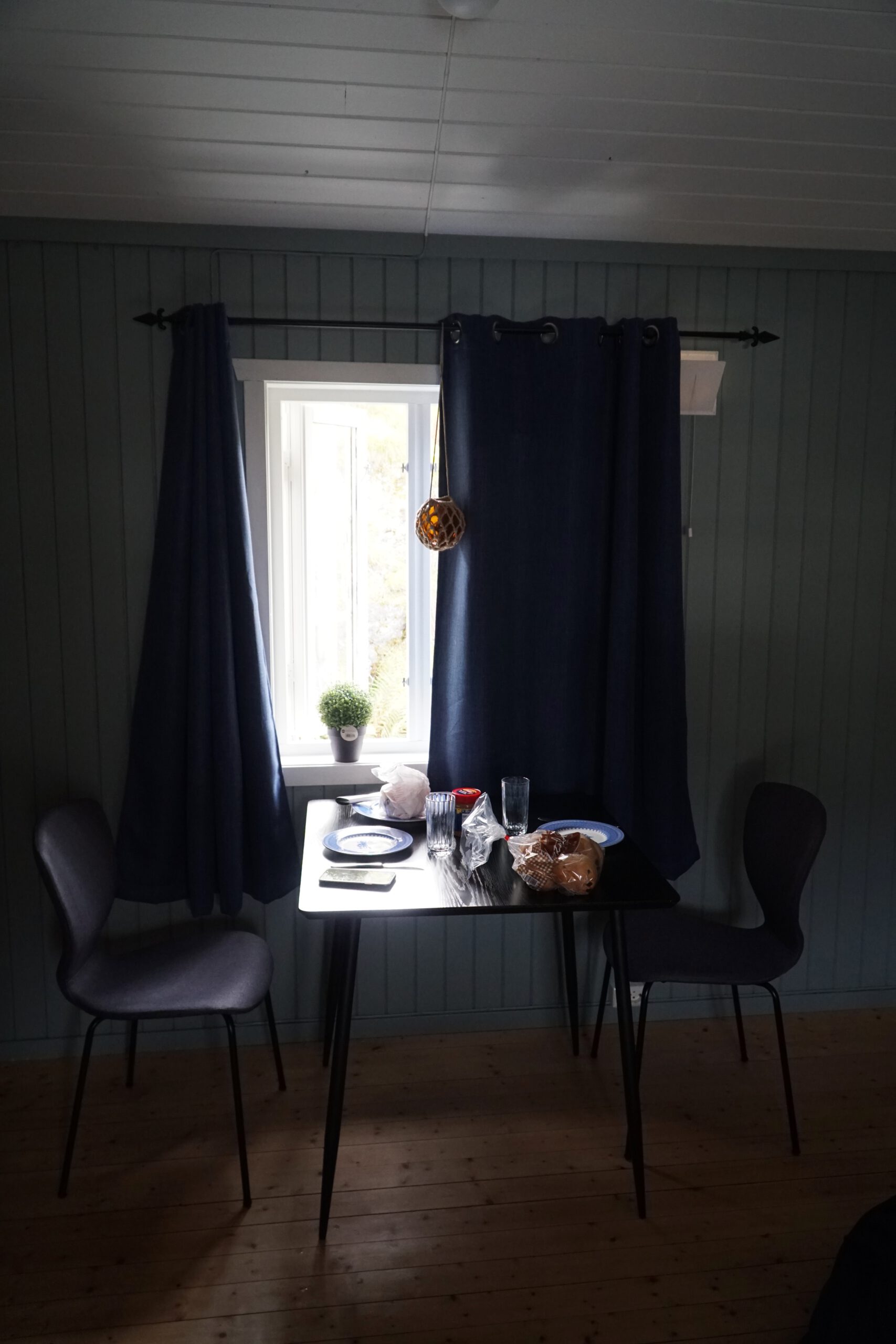 Breakfast inside The Tide Fisherman Cabins Sørvågen, morning breakfast table by the window inside a cozy fisherman cabin in Lofoten, Norway