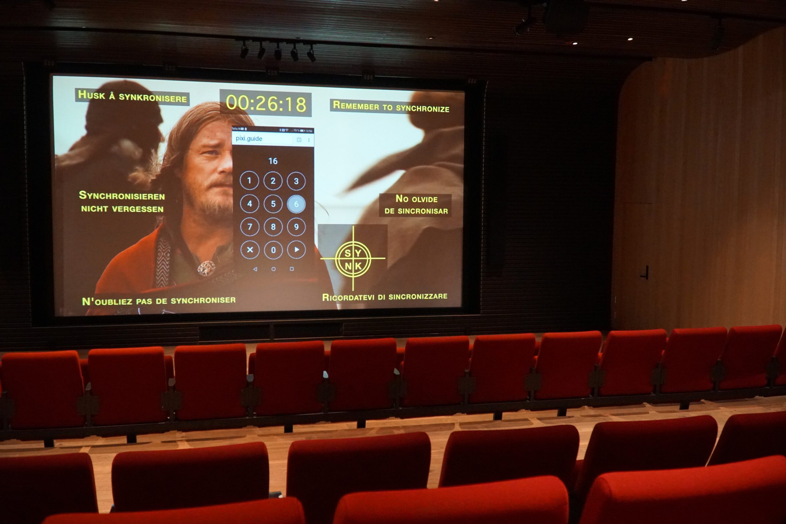 Lofotr Viking Museum cinema showing the introductory Viking film inside the main hall, with synchronized subtitles and storytelling about Viking life in Borg, Lofoten Islands