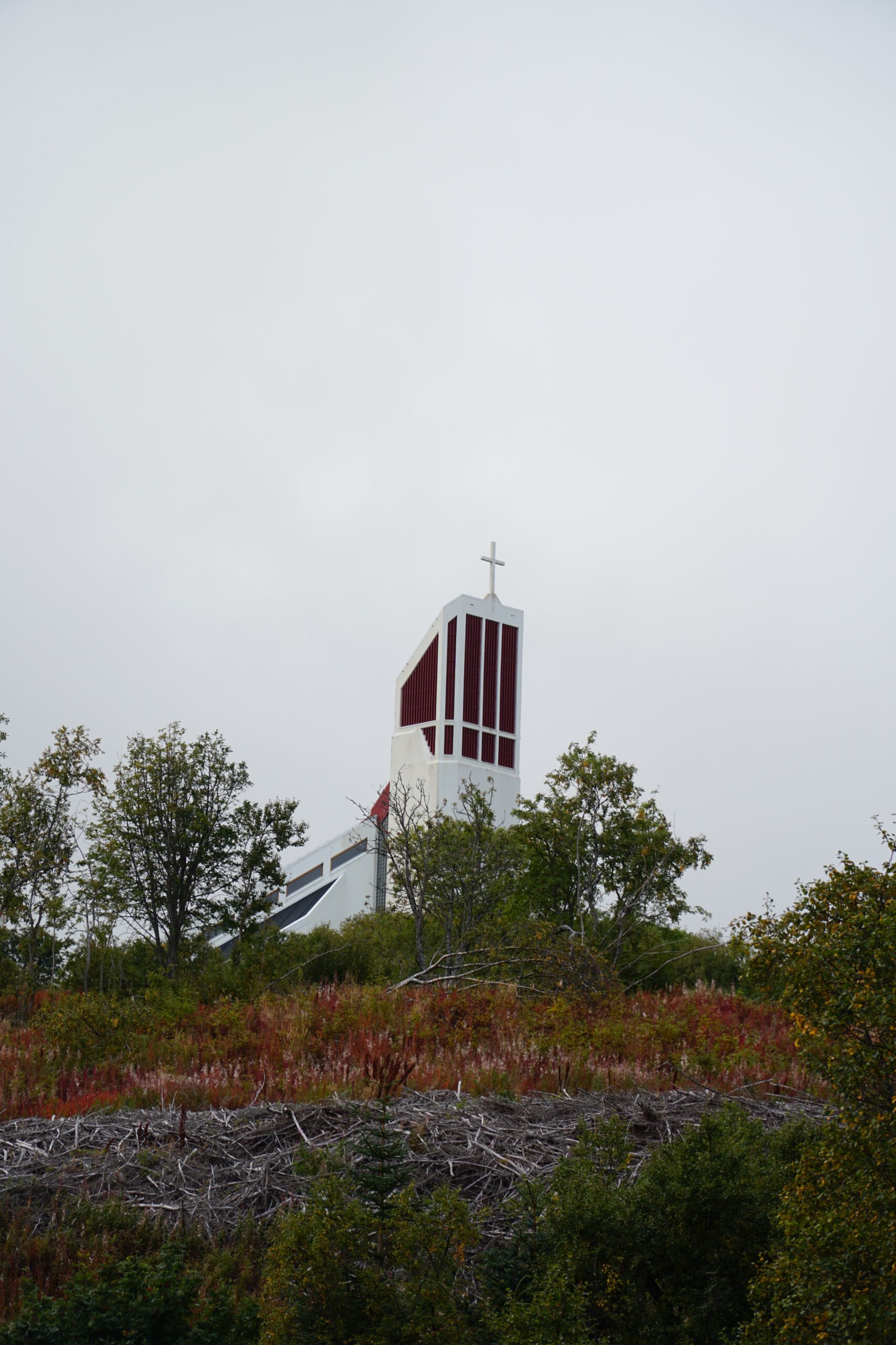Borge Church on Vestvågøy overlooking the Borg area, white and red church tower framed by autumn vegetation near the Lofotr Viking Museum