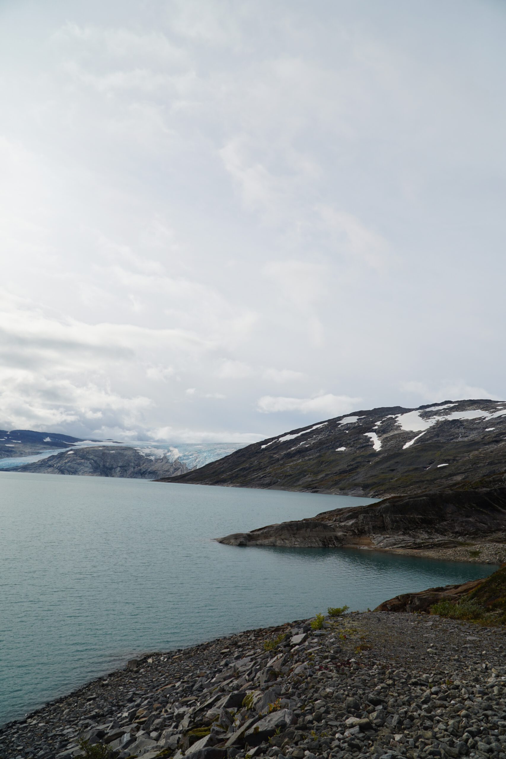 Wide view of Storglomvatnet with glacier ice visible in the distance, framed by steep mountains and Arctic wilderness