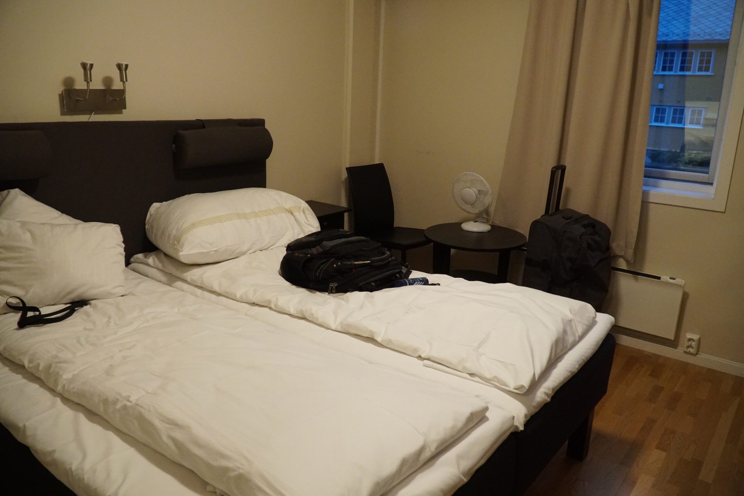 Støren Hotel Norway review twin bed setup with seating area and window in Trøndelag, highlighting simple room comfort and practical layout for road trippers