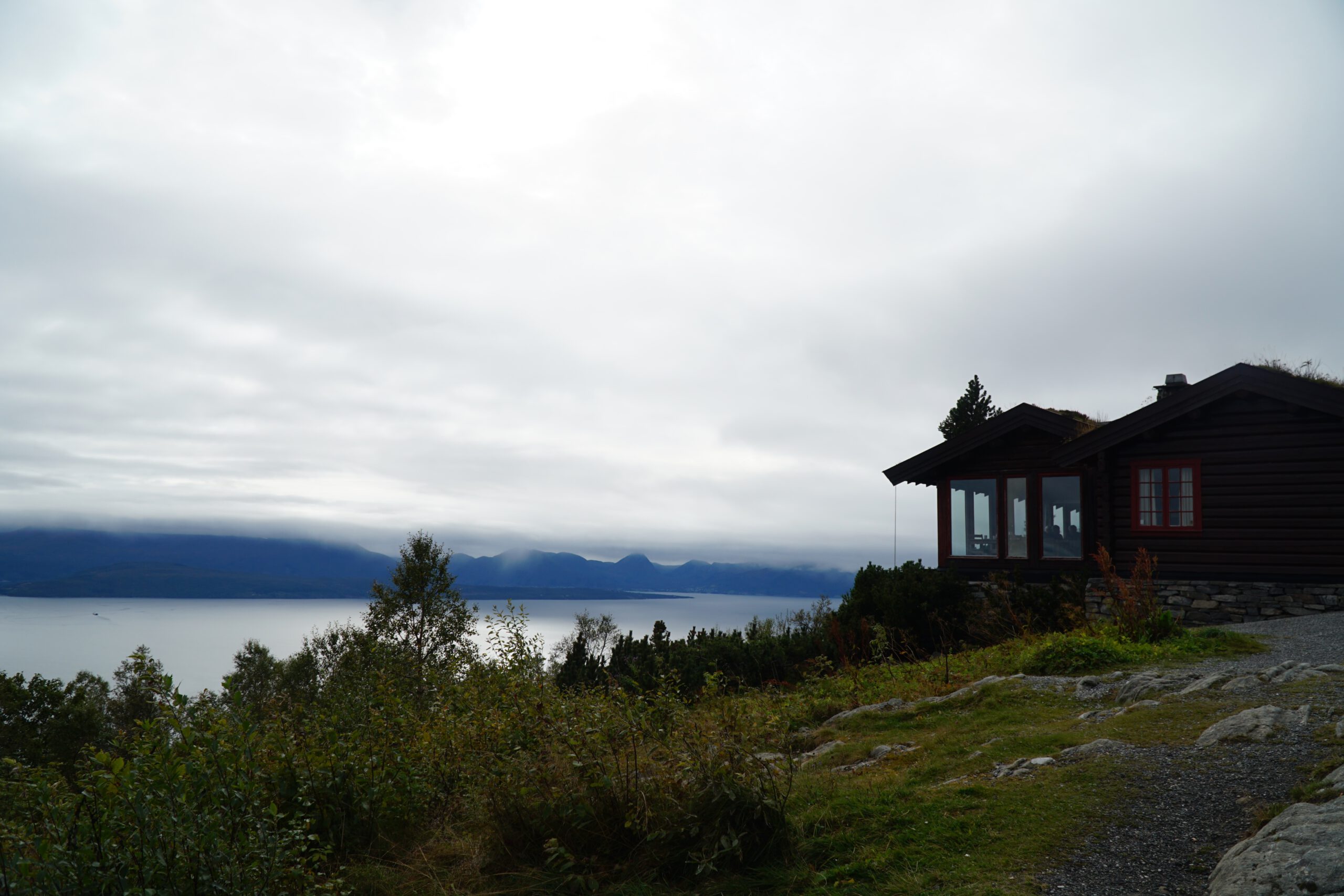 Vardestua Restaurant Molde view overlooking the fjord and mountain skyline, wooden cabin at 407 meters above sea level with dramatic cloudy sky above Molde Norway.