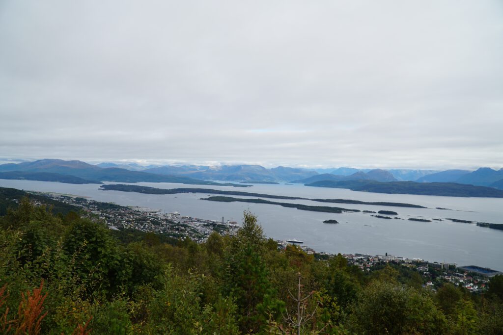 Vardestua Restaurant Molde panoramic view across Moldefjord and surrounding islands, dramatic mountain skyline under cloudy sky at 407 meters above sea level in Norway.