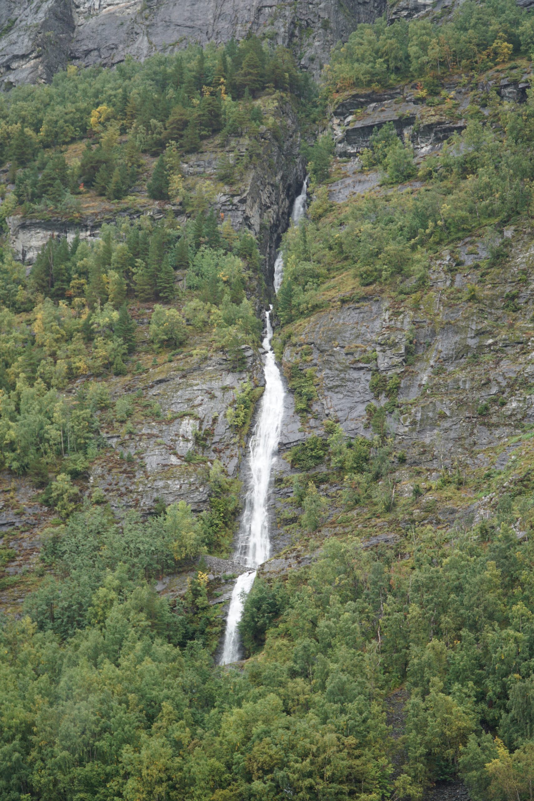 The Suitor waterfall flowing down steep rock walls in Geirangerfjord during the Geiranger Fjord and Waterfalls Sightseeing Boat Trip
