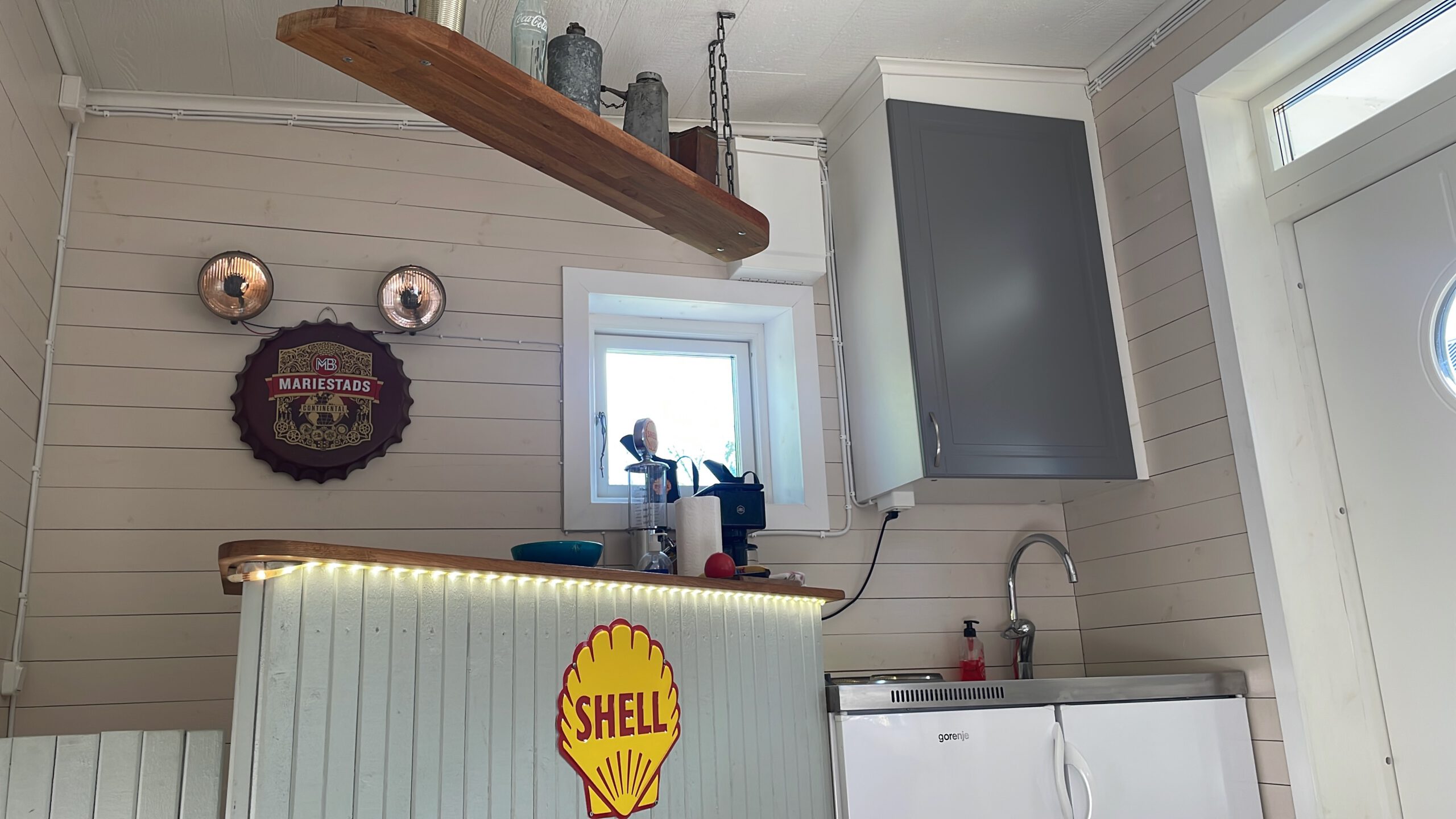 Shell Gas Station Airbnb Enkoping Sweden kitchen interior with vintage Shell bar, classic gas station decor, compact sink area and nostalgic lighting inside the unique Airbnb
