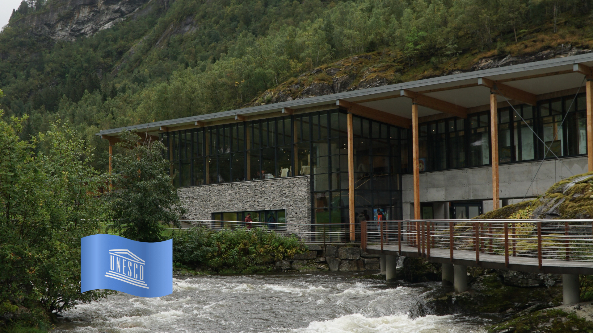 Norsk Fjordsenter Geiranger UNESCO visitor center building above the Kleivafossen rapids, modern architecture with glass facade surrounded by green mountains in Norway