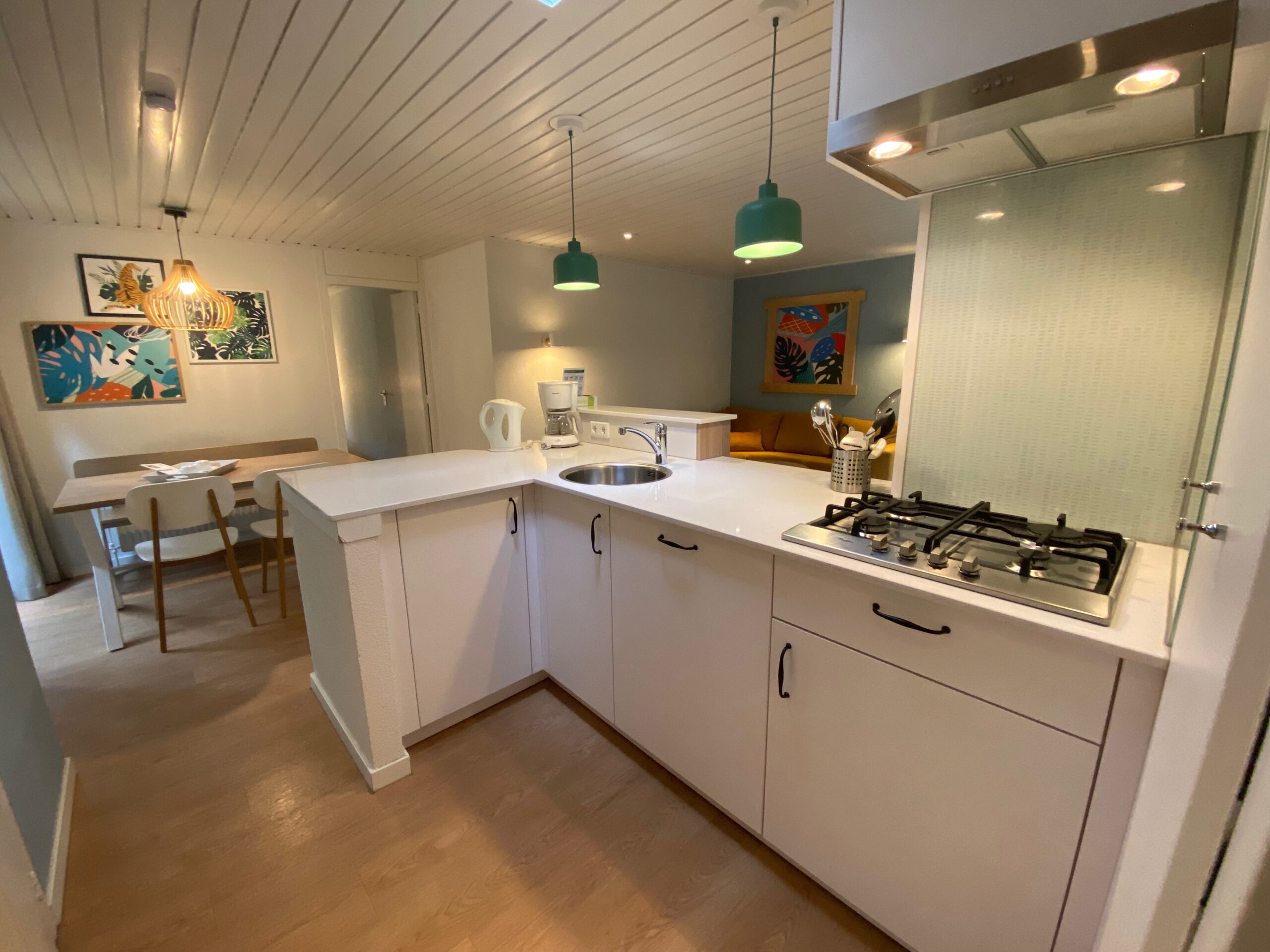 Kitchen with gas stove and bar counter in Center Parcs Het Heijderbos 4 pers Premium HB1922 cottage 965, modern open layout with fully equipped cooking area